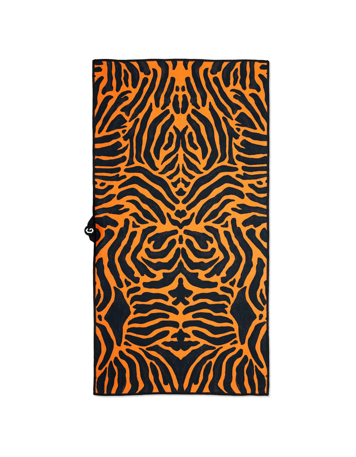 GEOMETRY’s Magna - Tiger towel features a bold, symmetrical orange and black tiger stripe design, made from recycled materials for ultra-absorbency. Shown laid flat on a white background.
