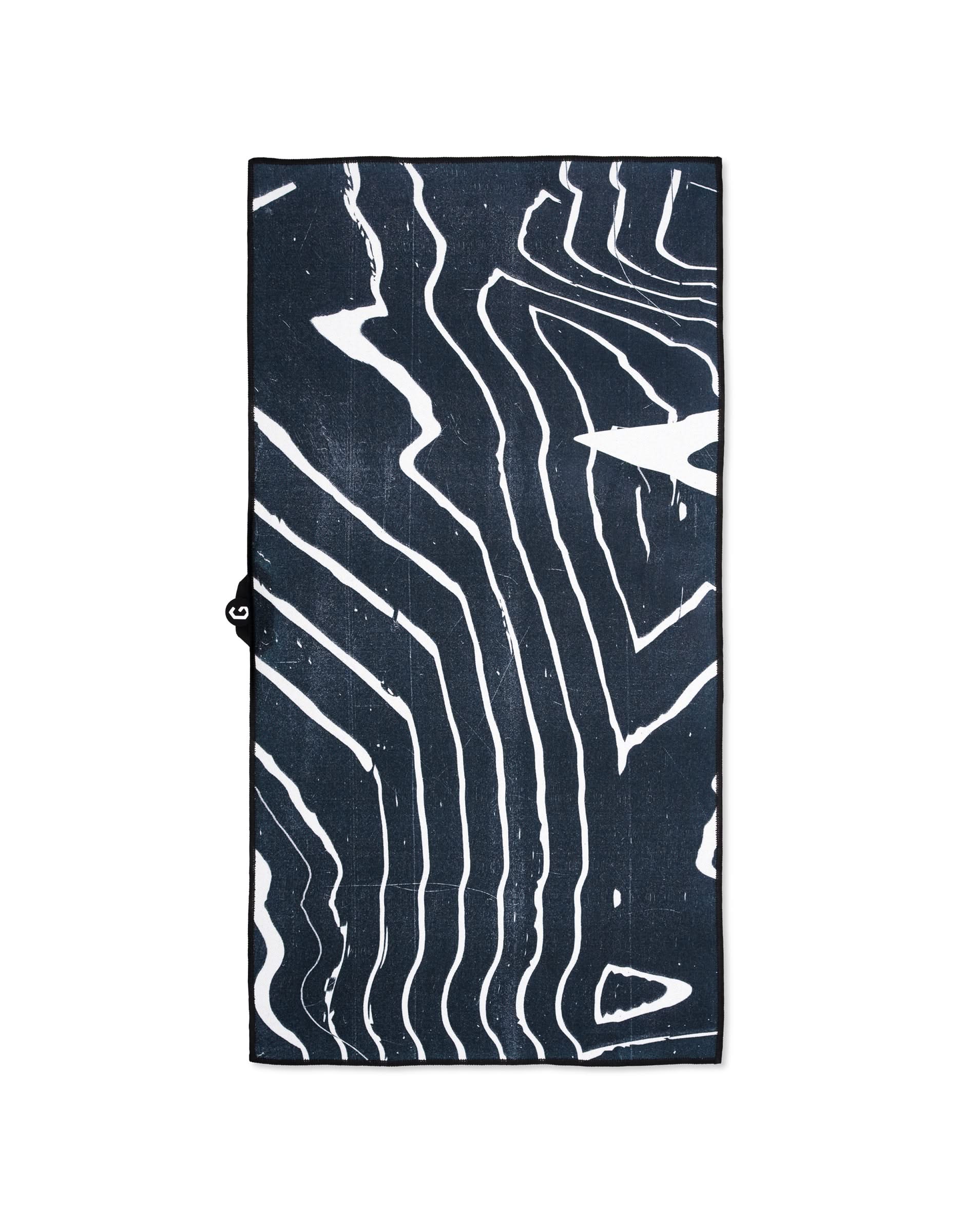 The GEOMETRY Magna - Ting is a rectangular black ultra-absorbent gym towel featuring bold, irregular white lines in an abstract, wavy pattern reminiscent of wood grain or topographic lines, displayed on a white background.
