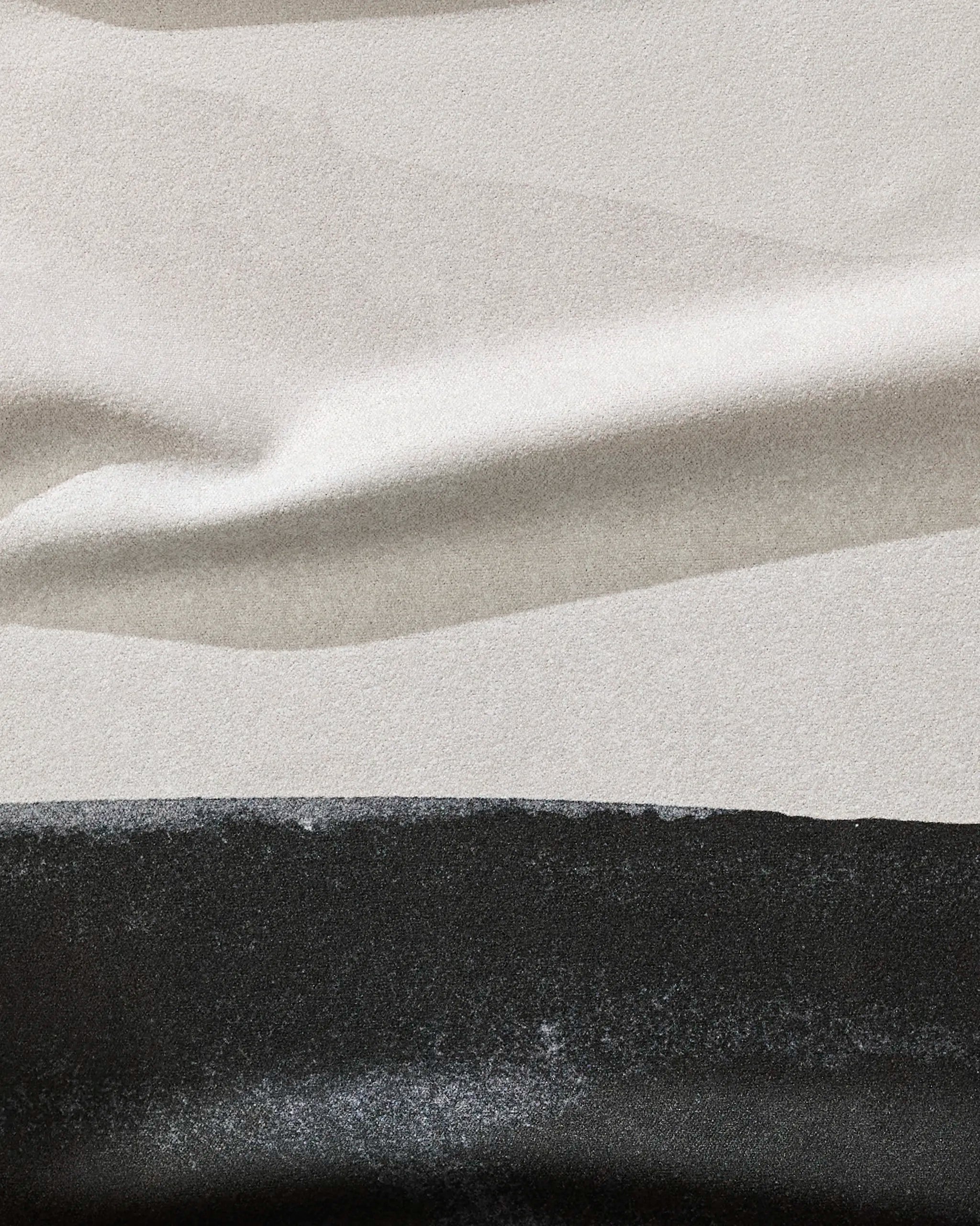 A close-up of GEOMETRY's Top Layer towel shows smooth, light gray and black recycled fabric with gentle folds, creating a soft abstract pattern—perfect for a stylish fitness accessory.