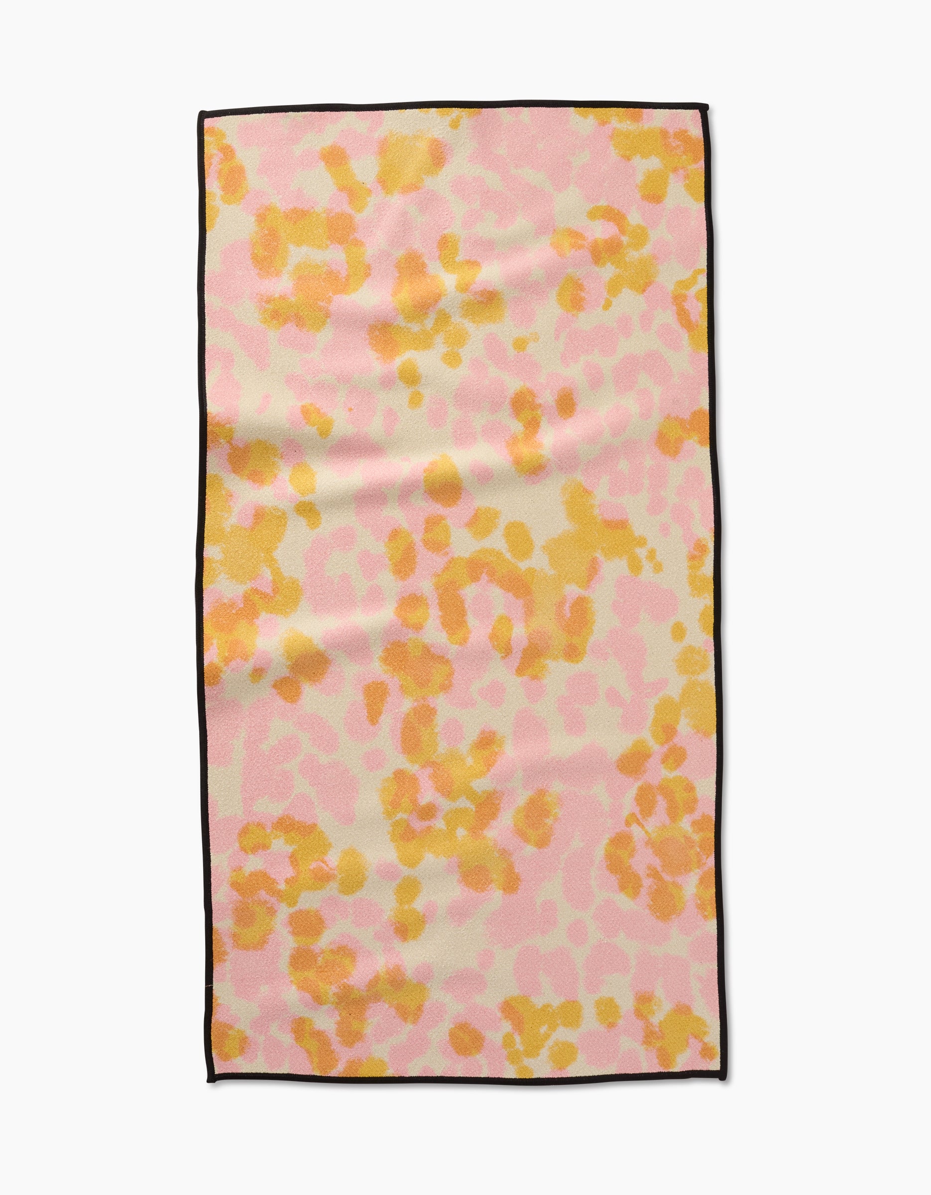 The GEOMETRY Whimsy towel is a rectangular fitness towel made from recycled materials, featuring a pink, orange, and yellow abstract spotted pattern with a thin black edge, shown on a white background.