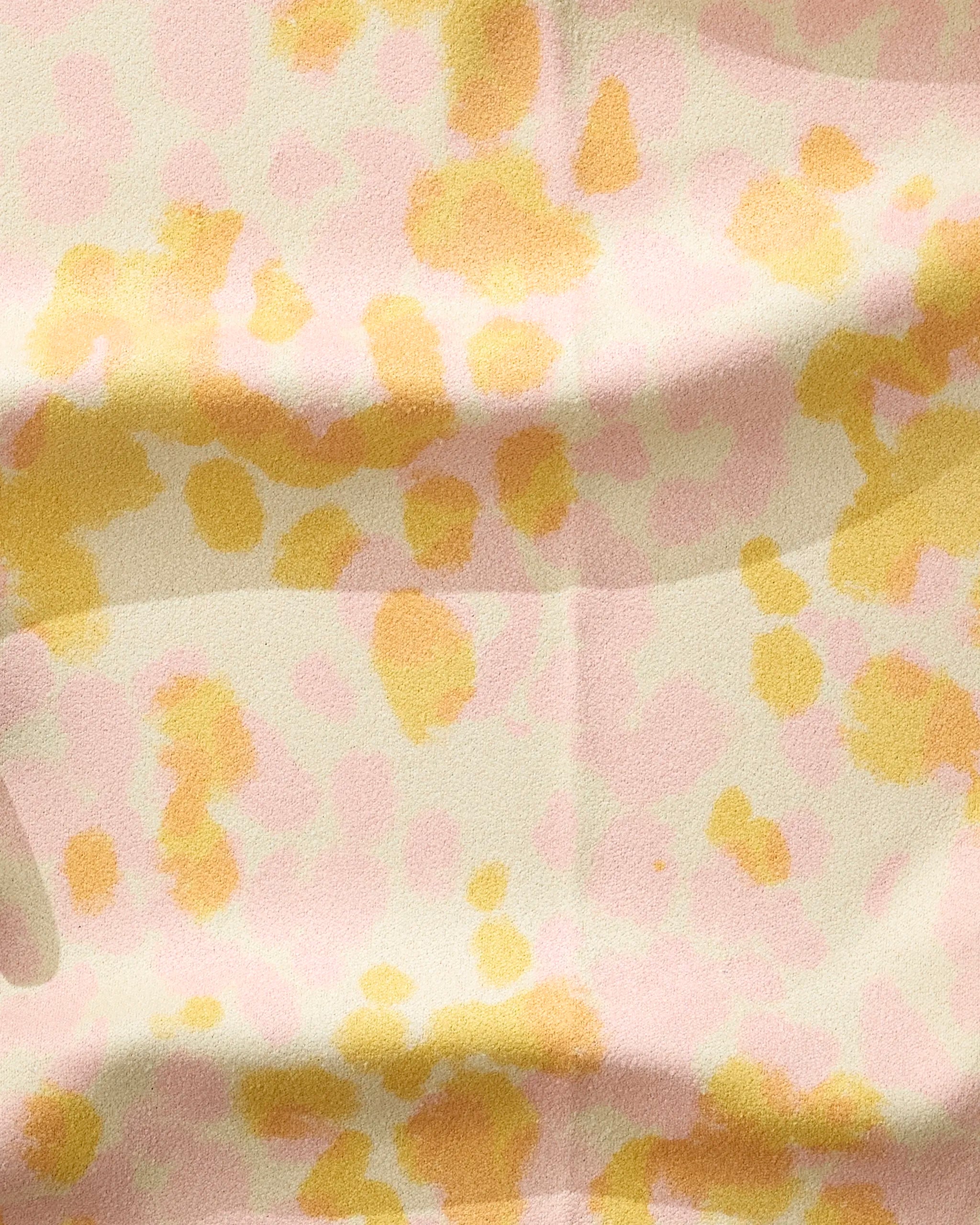 The GEOMETRY Whimsy fitness towel features a crème-colored fabric with soft, abstract yellow and light pink splotches. Made from recycled materials, it’s ultra-absorbent and stylish for sustainable workouts.