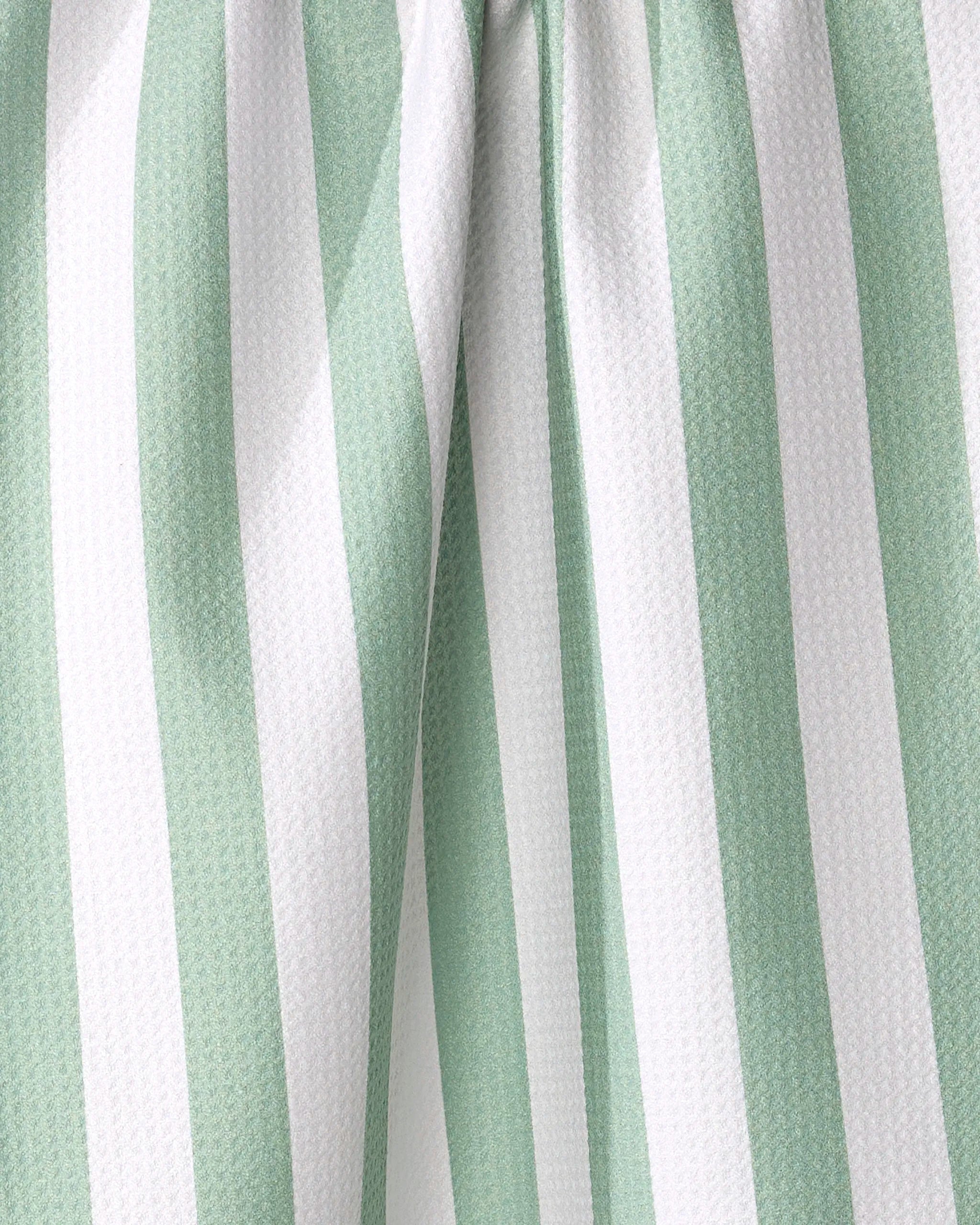 Close-up of the Mistletoe Striped tea towel by Kailee Wright, made from recycled materials with vertical white and light green stripes, slight folds, and a textured surface.