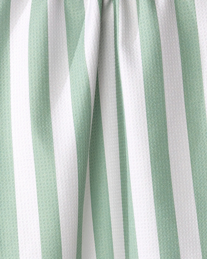 Close-up of the Mistletoe Striped tea towel by Kailee Wright, made from recycled materials with vertical white and light green stripes, slight folds, and a textured surface.