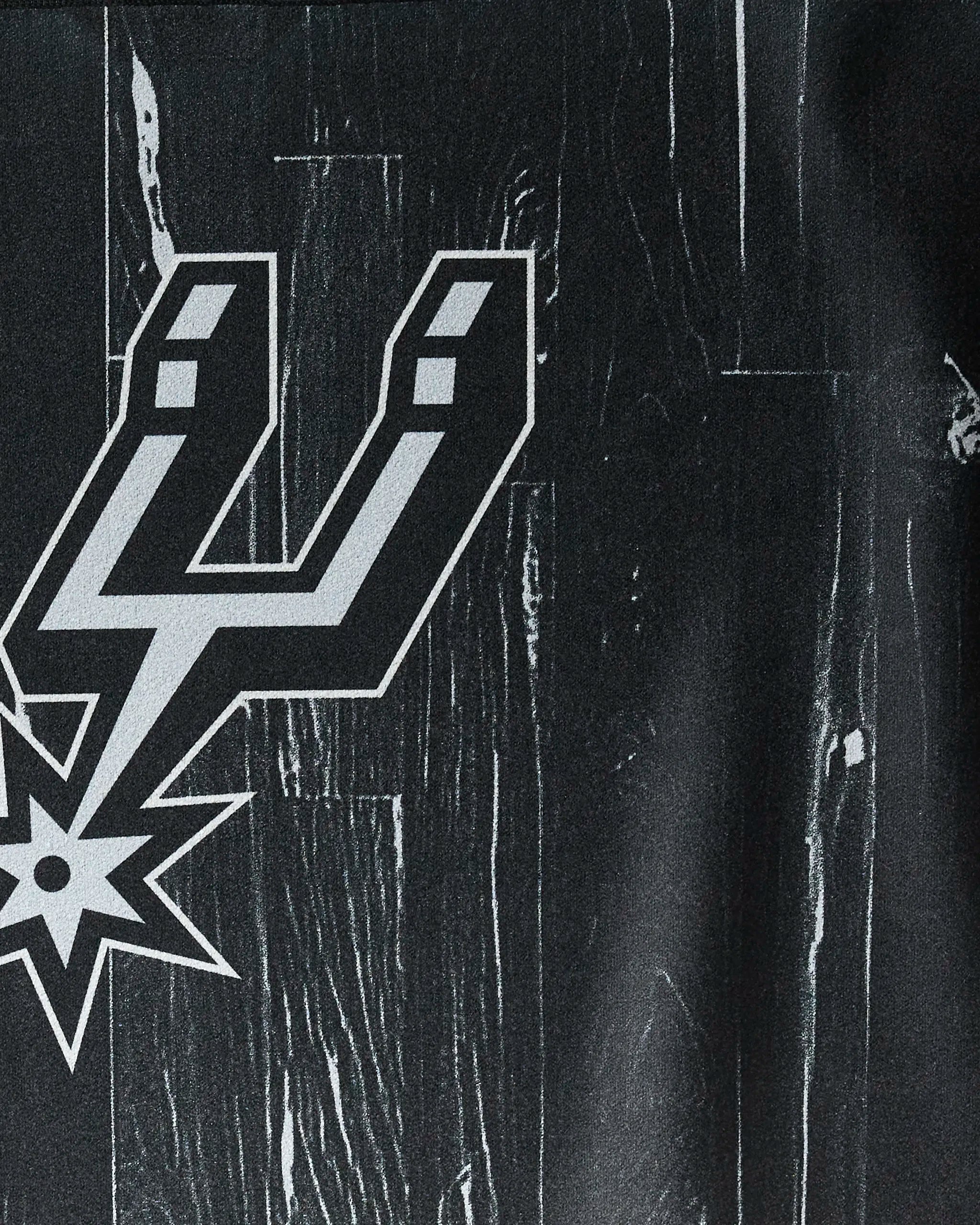 The image shows the Spurs Zone fitness towel by NBALAB x Geometry, featuring the San Antonio Spurs logo on a dark, wood-textured background—ideal for fans adding team spirit and style to their gym routine.