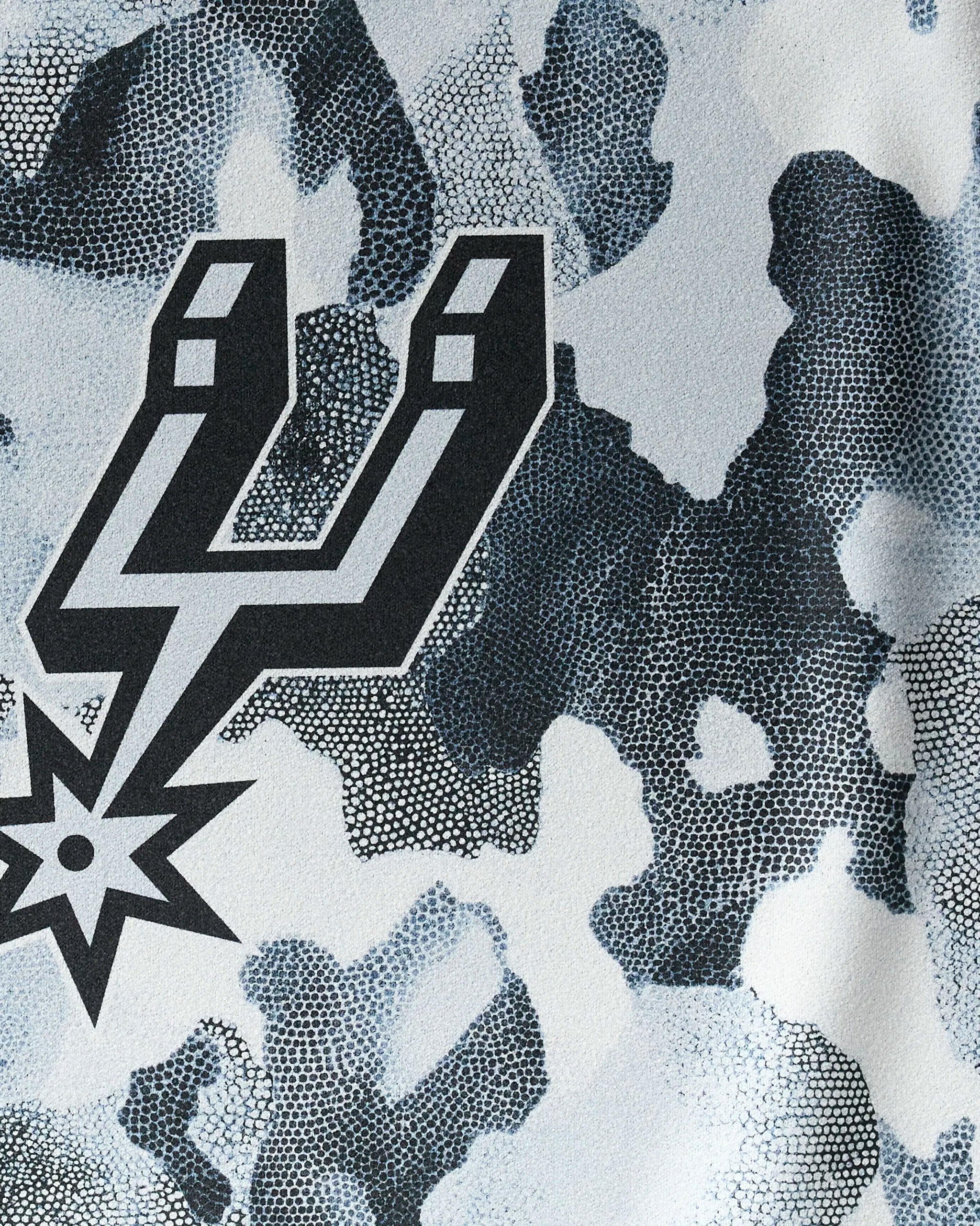 The NBALAB x Geometry Spurs Camo fitness towel showcases a San Antonio Spurs logo over blue, gray, and white camo with a dotted texture—a stylish gym essential for any NBA fan.