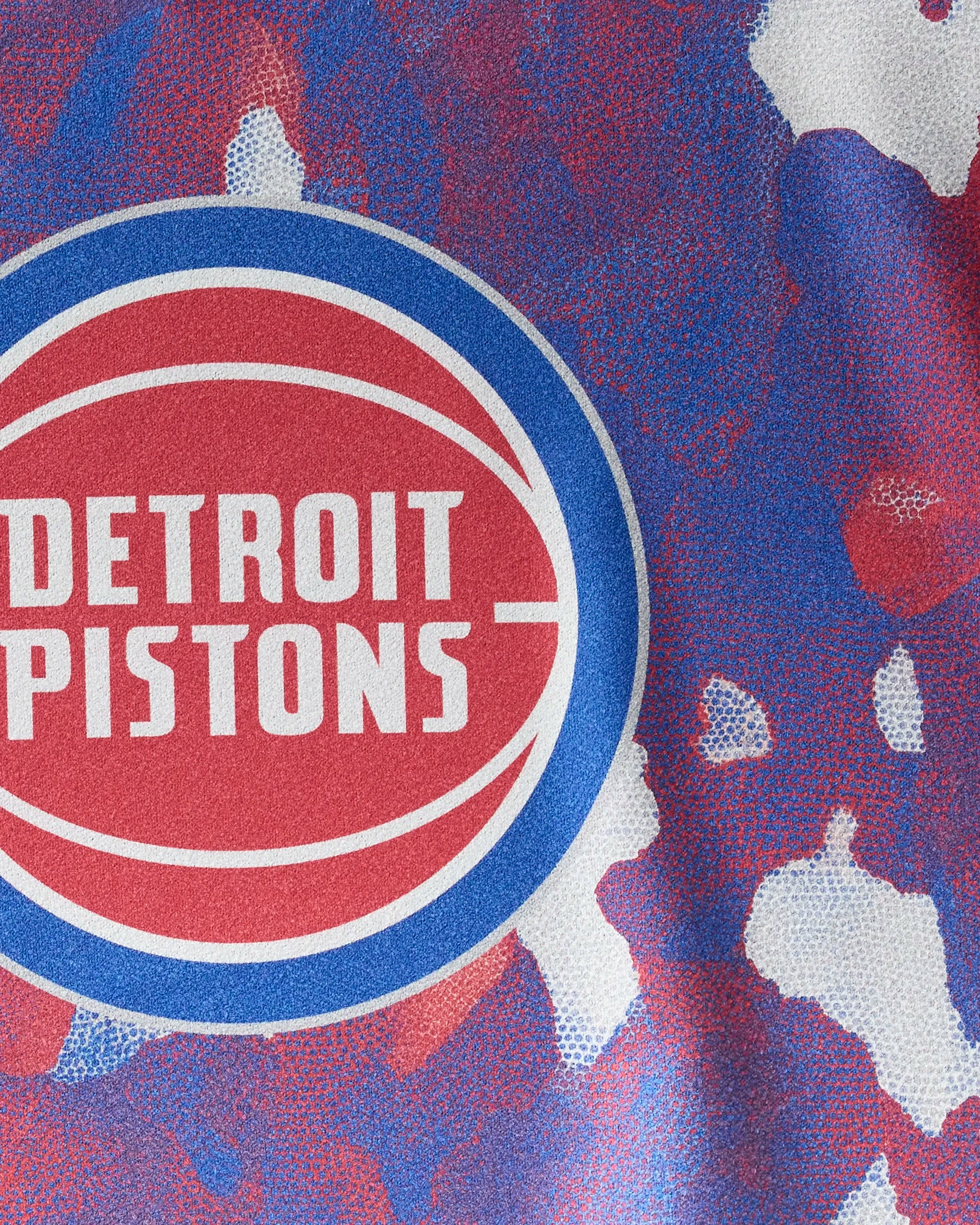 Close-up of a Pistons Camo towel by NBALAB x Geometry, showcasing the Detroit Pistons logo on quick-drying workout fabric with a red, blue, and white camouflage pattern.