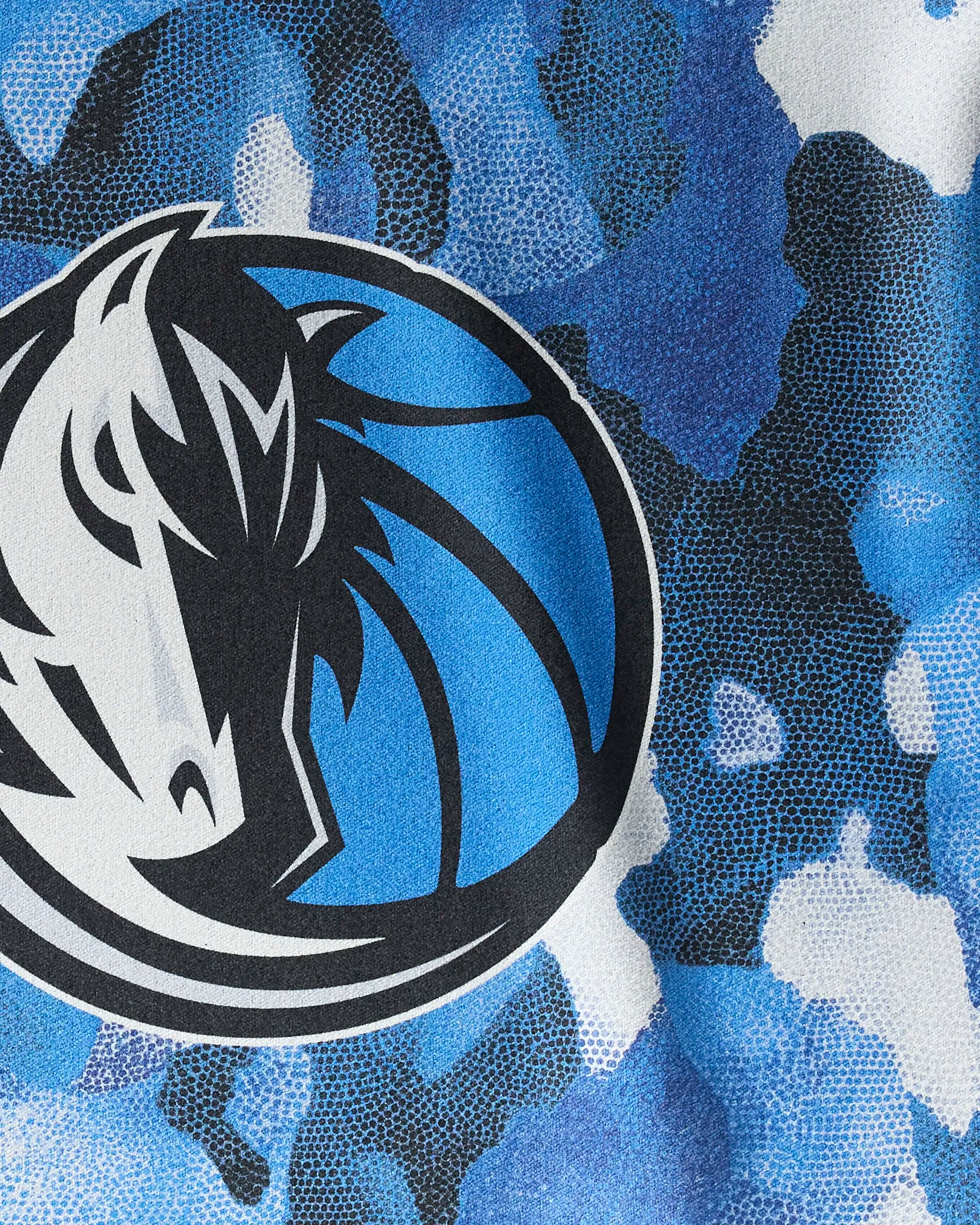 Close-up of the Mavericks Camo gym towel by NBALAB x Geometry, a quick-drying towel with textured blue, black, and white camo patterns and the Dallas Mavericks horse head logo inside a blue basketball.