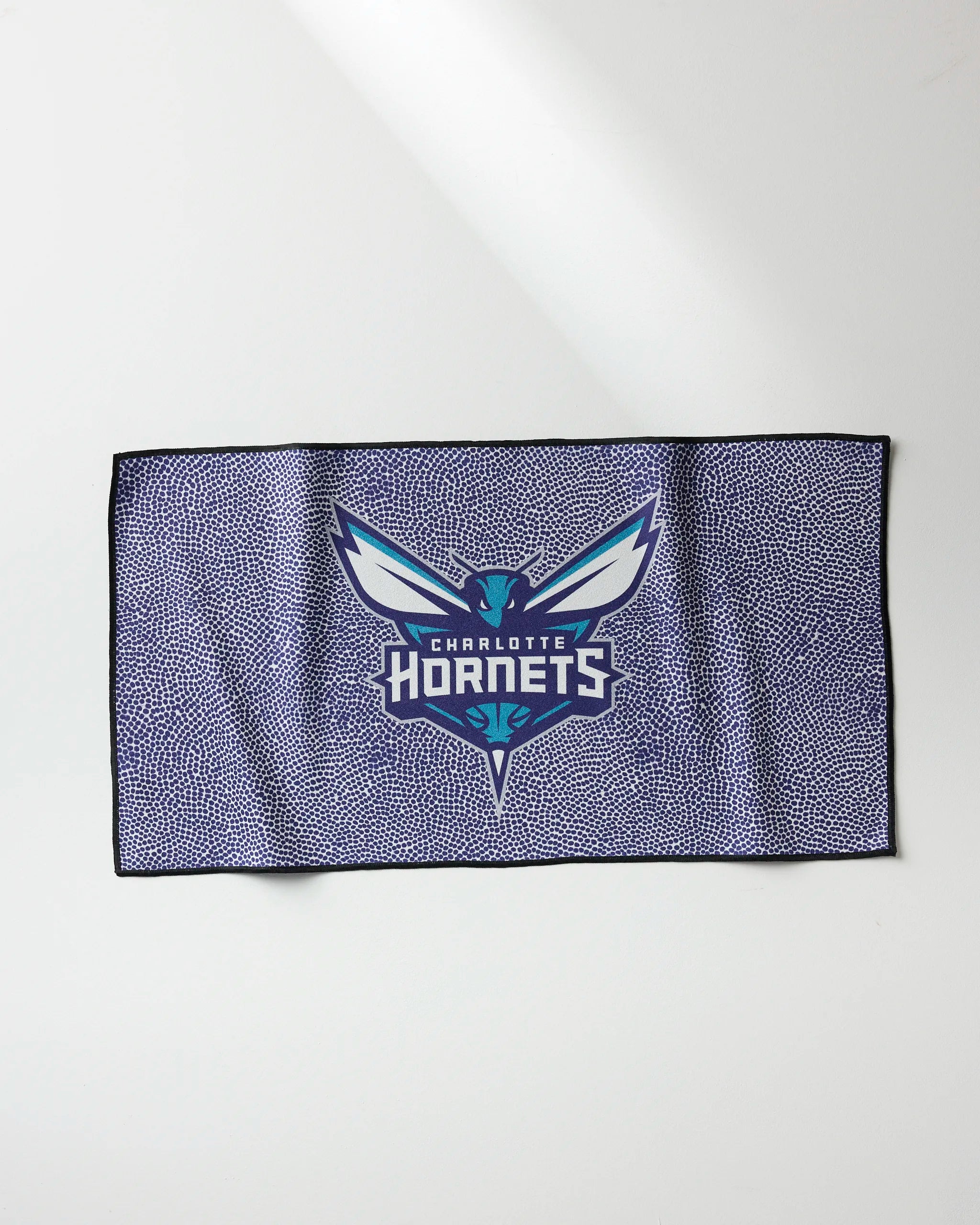 The NBALAB x Geometry Hornets Grip is a rectangular fitness towel with a purple speckled design and the Charlotte Hornets logo centered, displayed flat on a light surface.