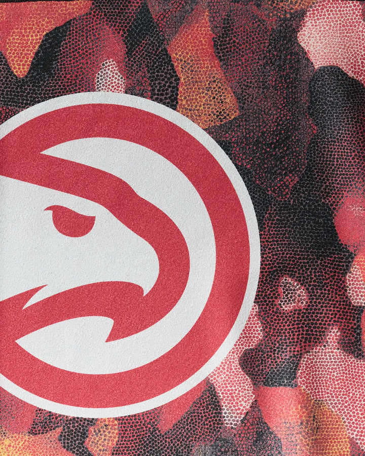 Close-up of the Hawks Camo by NBALAB x Geometry—a camo-inspired fitness towel featuring the Atlanta Hawks' red hawk head logo in a circle, perfect for NBA fans seeking a sustainable gym accessory.