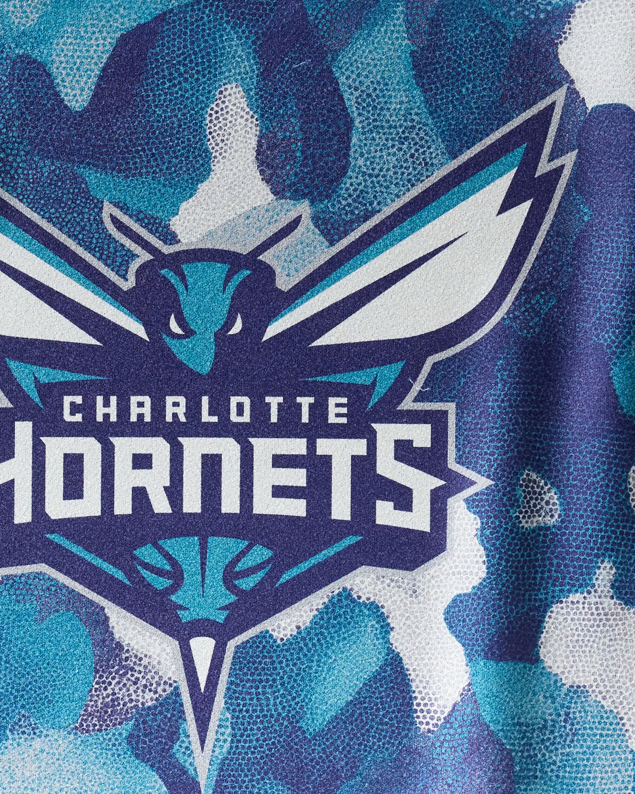 Show off your Hornets pride with the NBALAB x Geometry "Hornets Camo" towel, featuring a stylized hornet and team name in bold white on a blue, teal, and white camo background—the perfect sustainable NBA gym accessory.