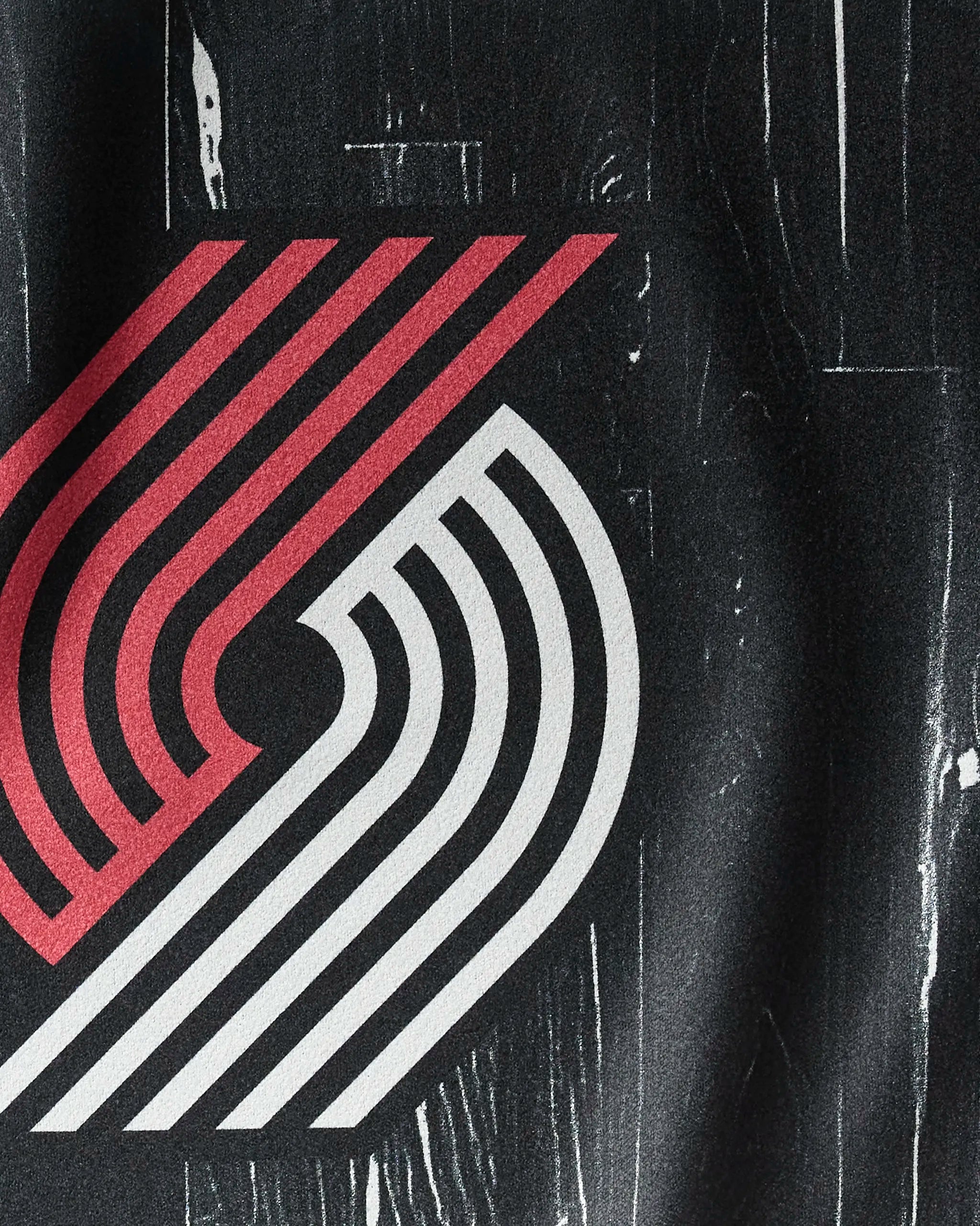 Close-up of the Trail Blazers Zone logo with red and white pinwheel lines on textured black, by NBALAB x Geometry—perfect for an NBA fitness towel design.