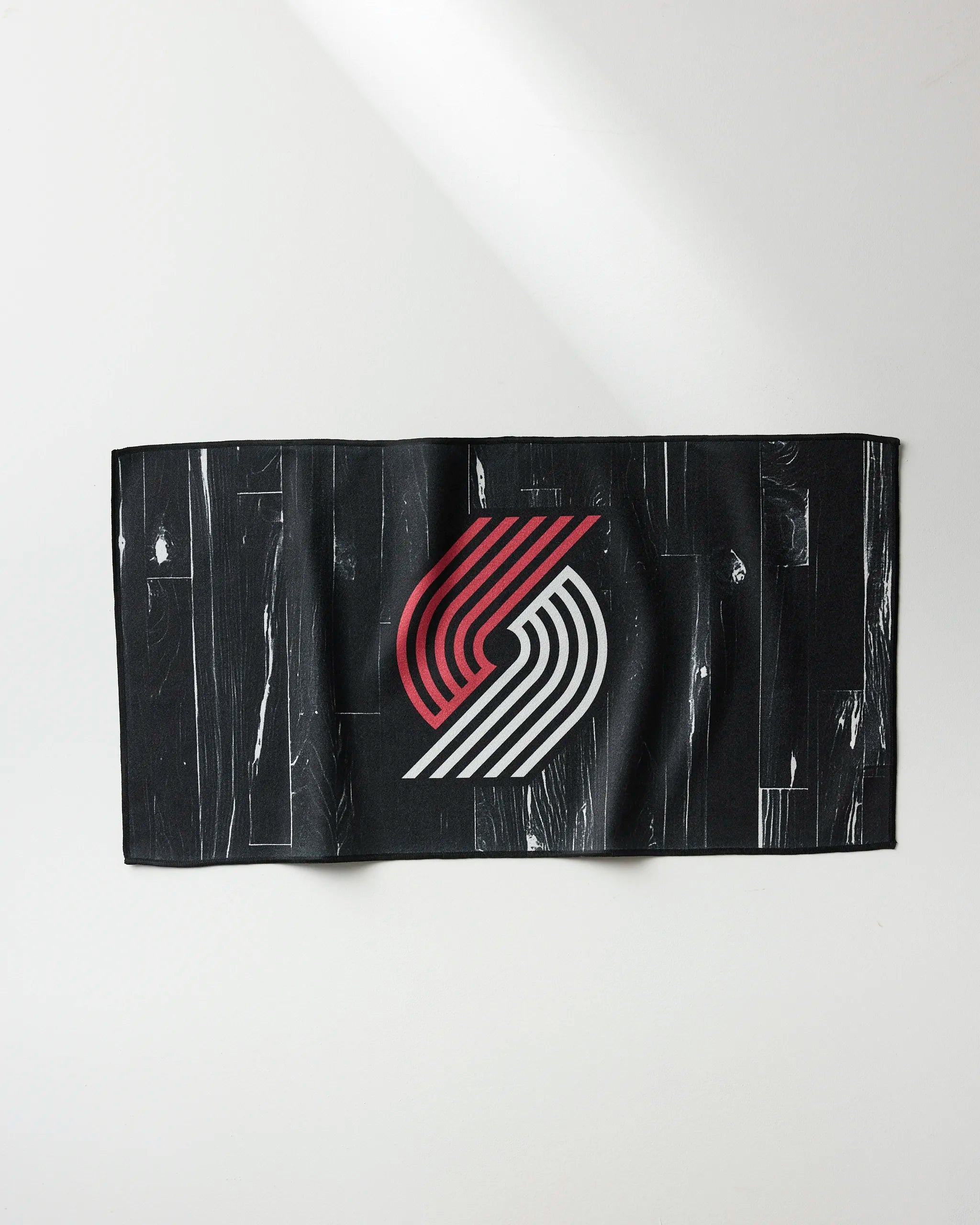 The NBALAB x Geometry Trail Blazers Zone is a black rectangular fitness towel with the Portland Trail Blazers logo in red and white, shown on a white background.