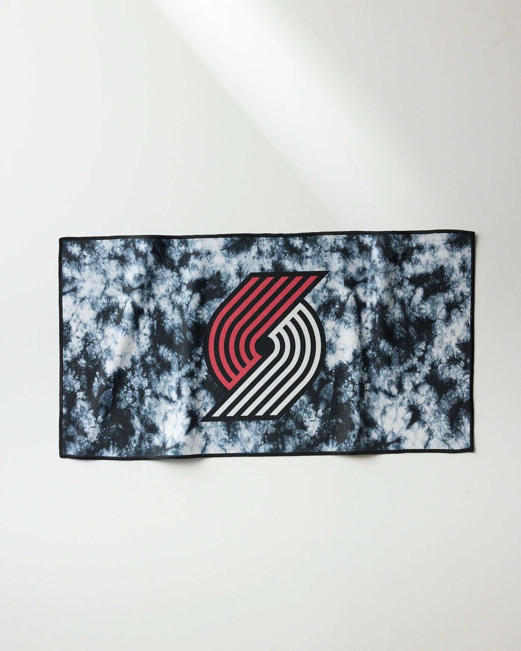 The Trail Blazers Flash by NBALAB x Geometry is a rectangular, quick-drying workout towel with a black, white, and blue tie-dye pattern and Portland Trail Blazers logo—your essential NBA fitness accessory.