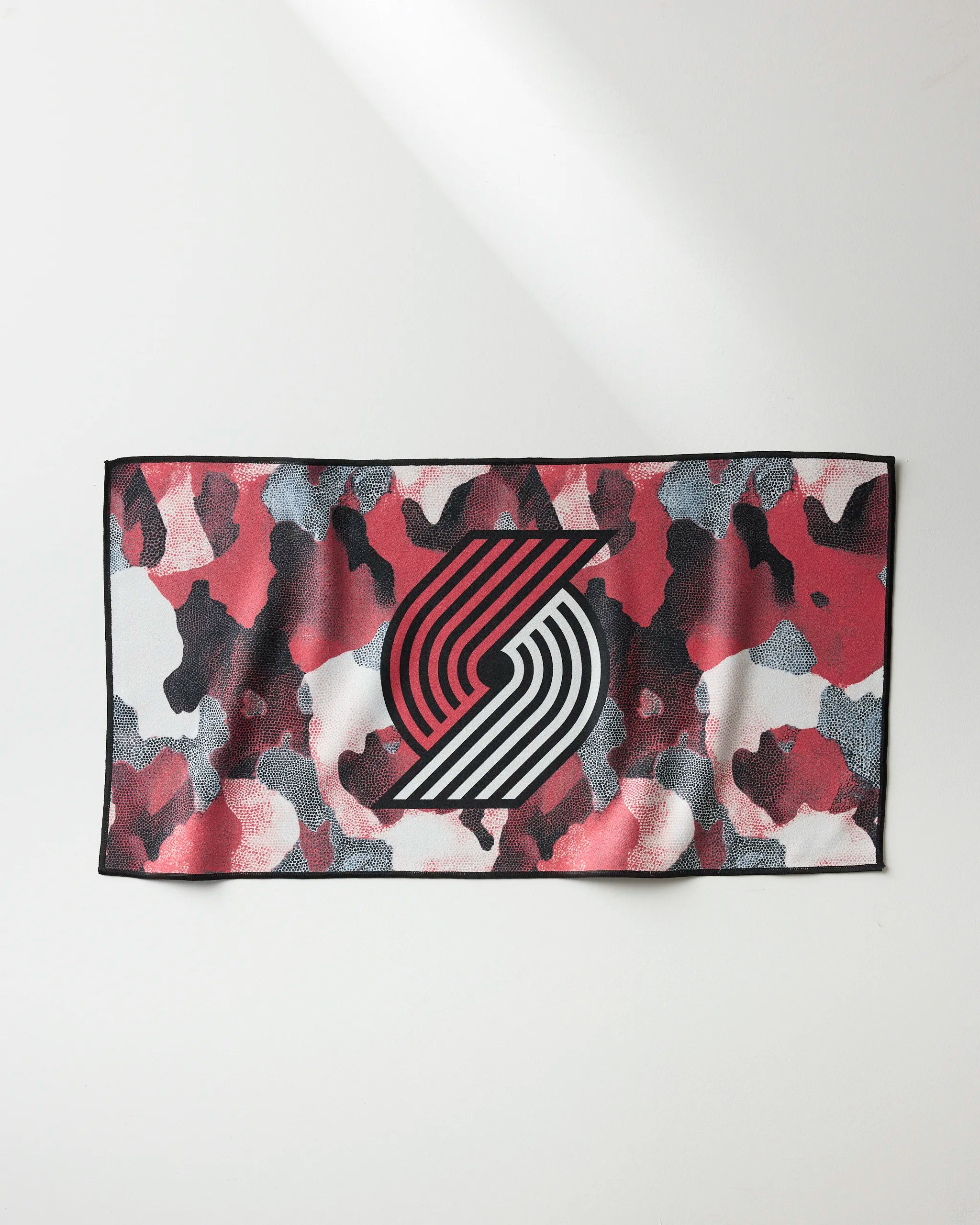 The Trail Blazers Camo by NBALAB x Geometry is a rectangular NBA fitness towel featuring red, black, and white camo with the Portland Trail Blazers logo—ideal as a quick-drying workout towel for fans.