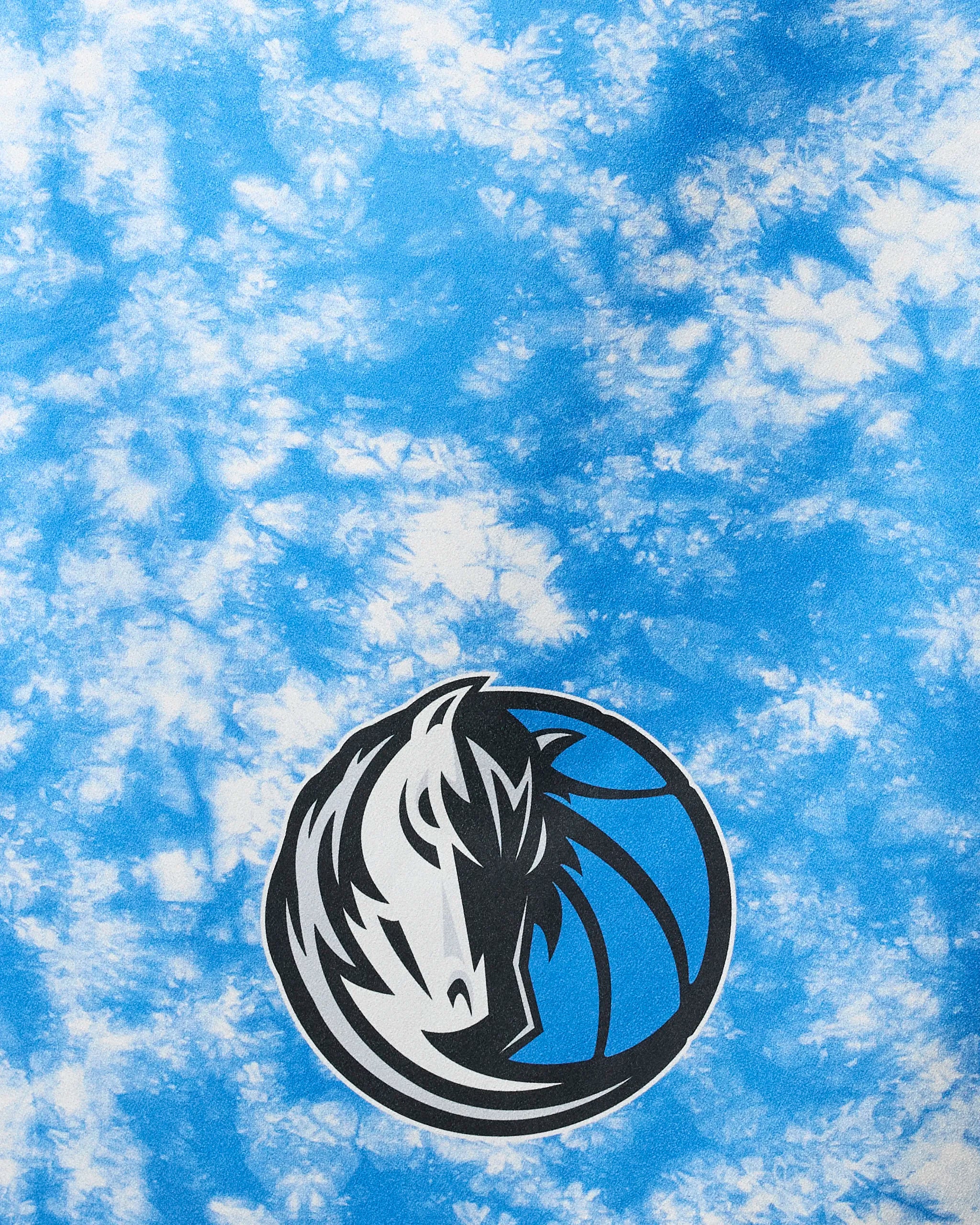 The Mavericks Flash NBA beach towel by NBALAB x Geometry features a blue and white tie-dye background with the Dallas Mavericks logo, crafted from recycled materials.