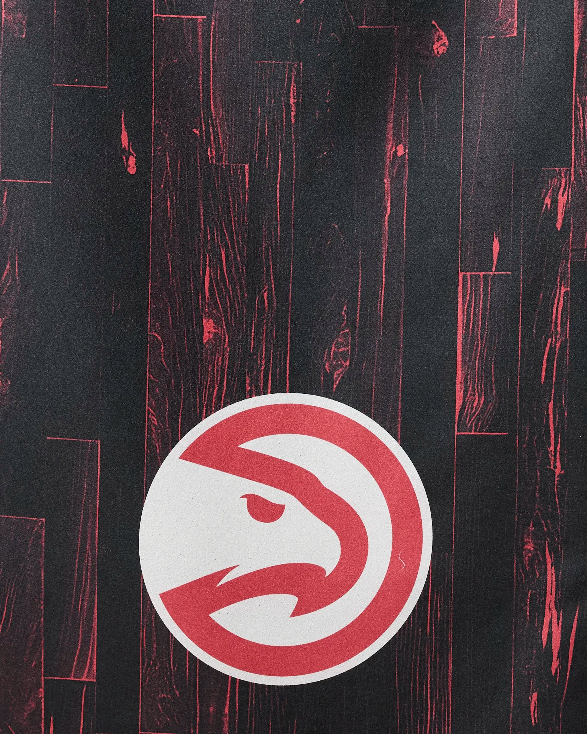 The image features the Hawks Zone by NBALAB x Geometry: a stylized red hawk head in a white circle centered on a dark basketball court floor with red wood grain, ideal for an eco-friendly NBA Beach Towel made from recycled materials.