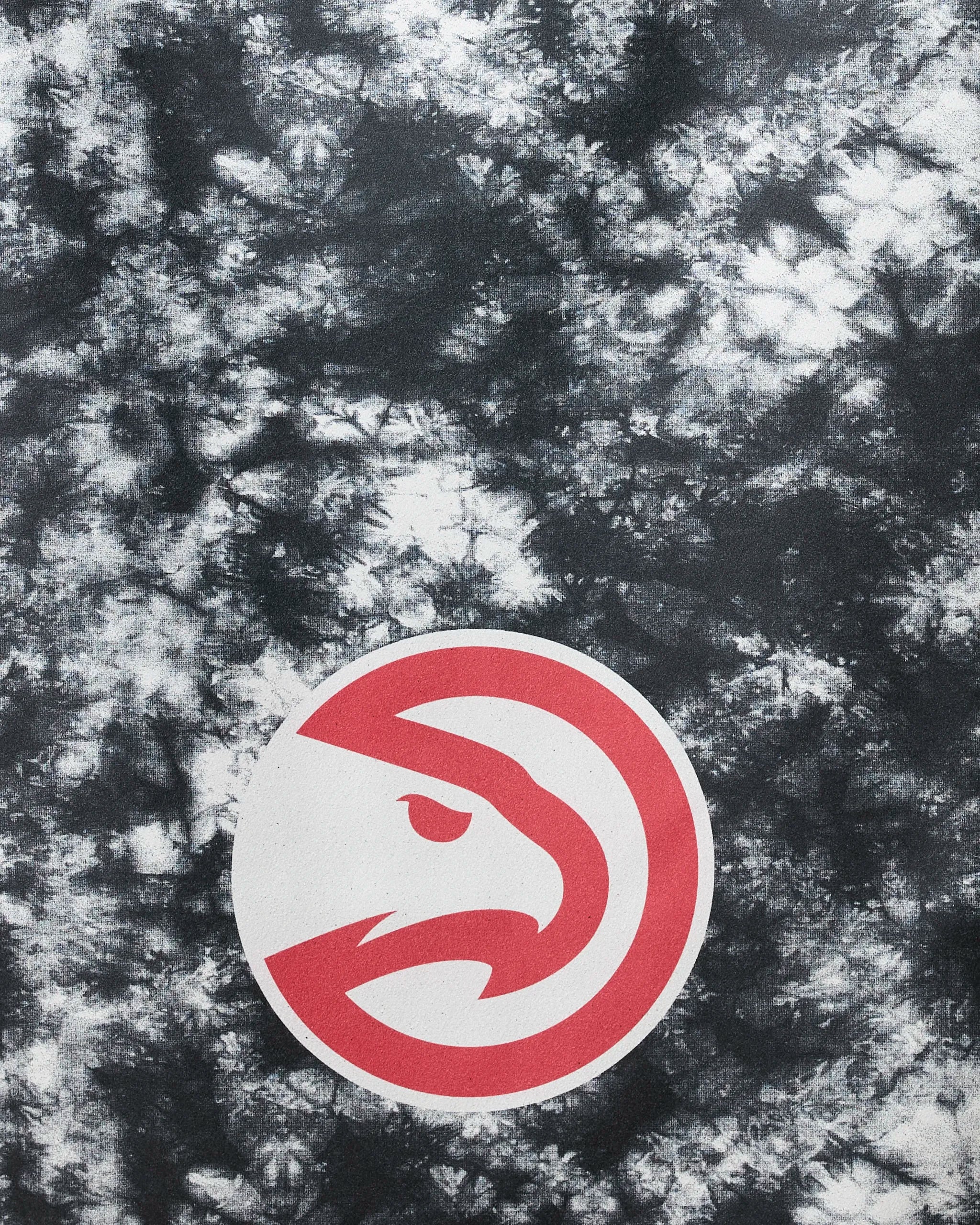 The Hawks Flash NBA beach towel by NBALAB x Geometry features a red and white stylized Atlanta Hawks hawk head logo within a circle on a black and white marbled tie-dye design, crafted from recycled materials.