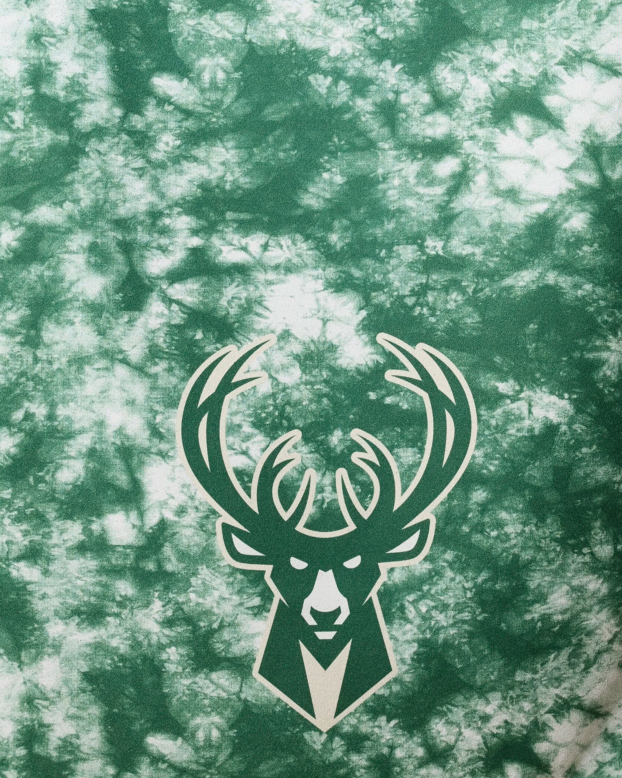 The Bucks Flash by NBALAB x Geometry is a green and white tie-dye beach towel with the Milwaukee Bucks logo, NBA licensed, and made from recycled materials for eco-friendly style—perfect for fans.