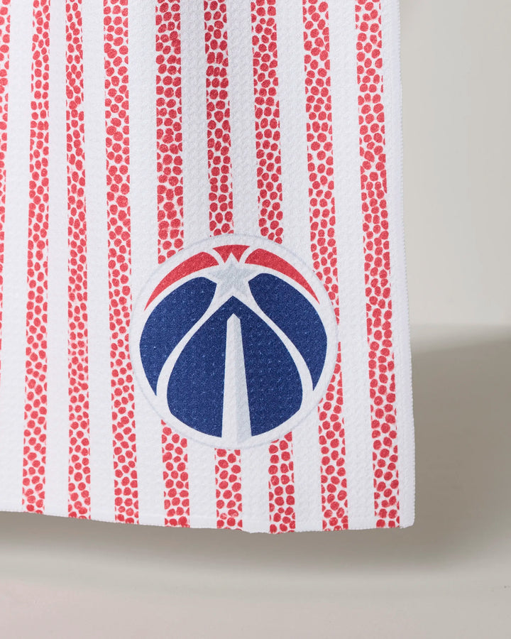 A close-up of the Wizards Grip Stripe tea towel from NBALAB x Geometry, featuring vertical red dotted stripes and the Washington Wizards logo near the bottom edge.