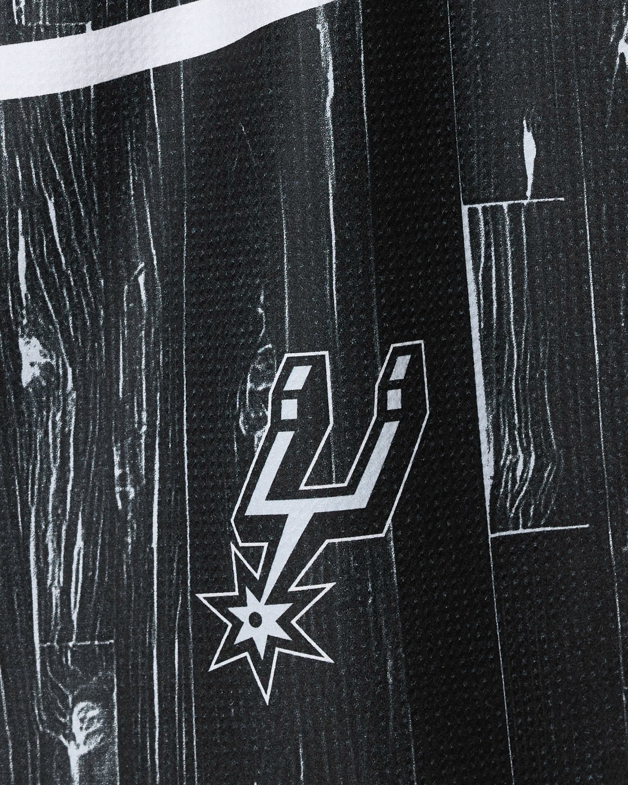 Close-up of the "Spurs Zone" tea towel by NBALAB x Geometry, featuring the San Antonio Spurs logo in white on a black woodgrain pattern—an ideal sustainable kitchen towel for fans.