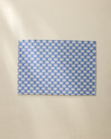 The Geometry Lagoon is a rectangular, machine washable placemat featuring a blue and white geometric design, shown lying flat on a light beige surface.