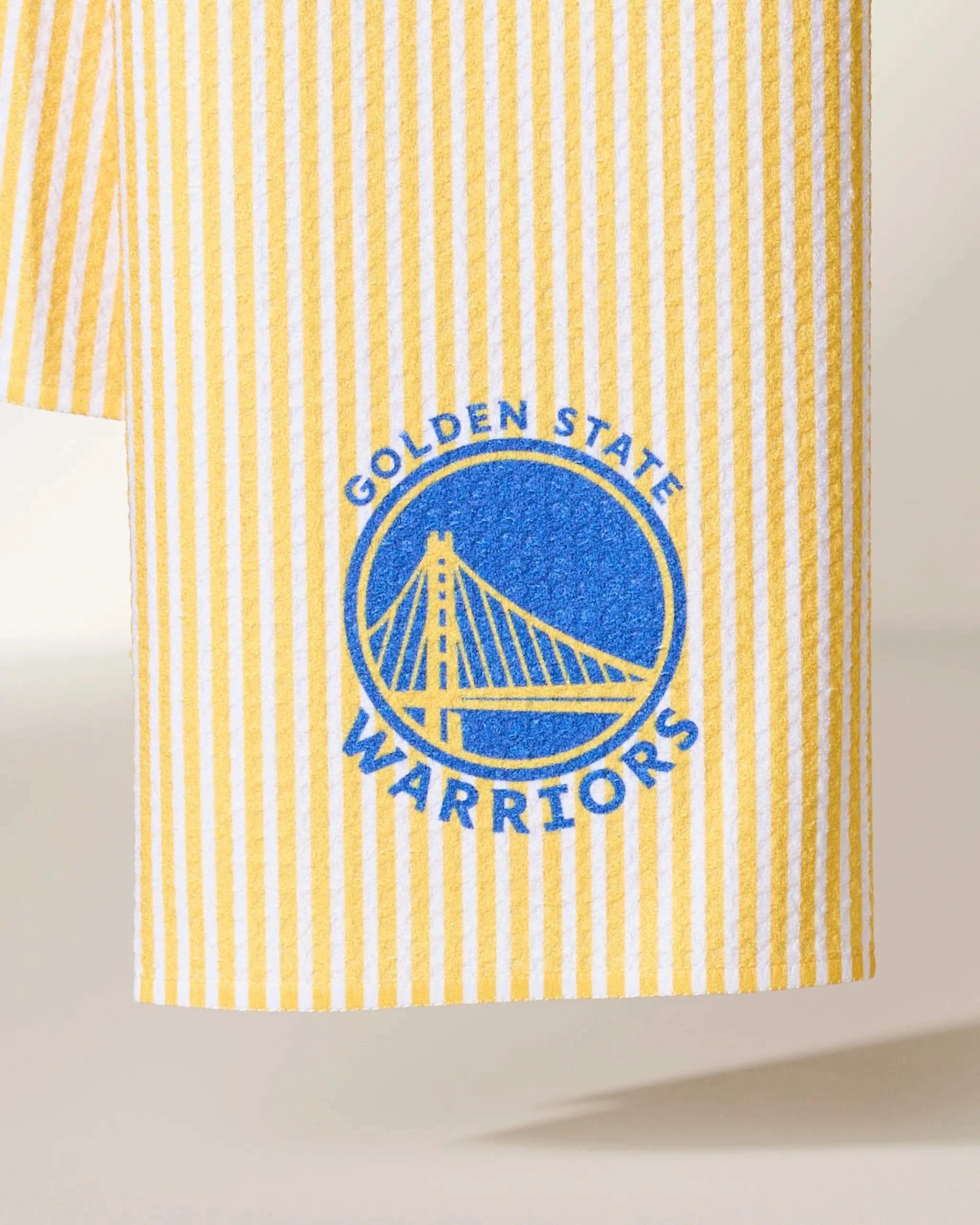 Geometry’s Warriors Classic features yellow and white stripes with the Golden State Warriors blue logo—a stylized suspension bridge and team name in a circular design.
