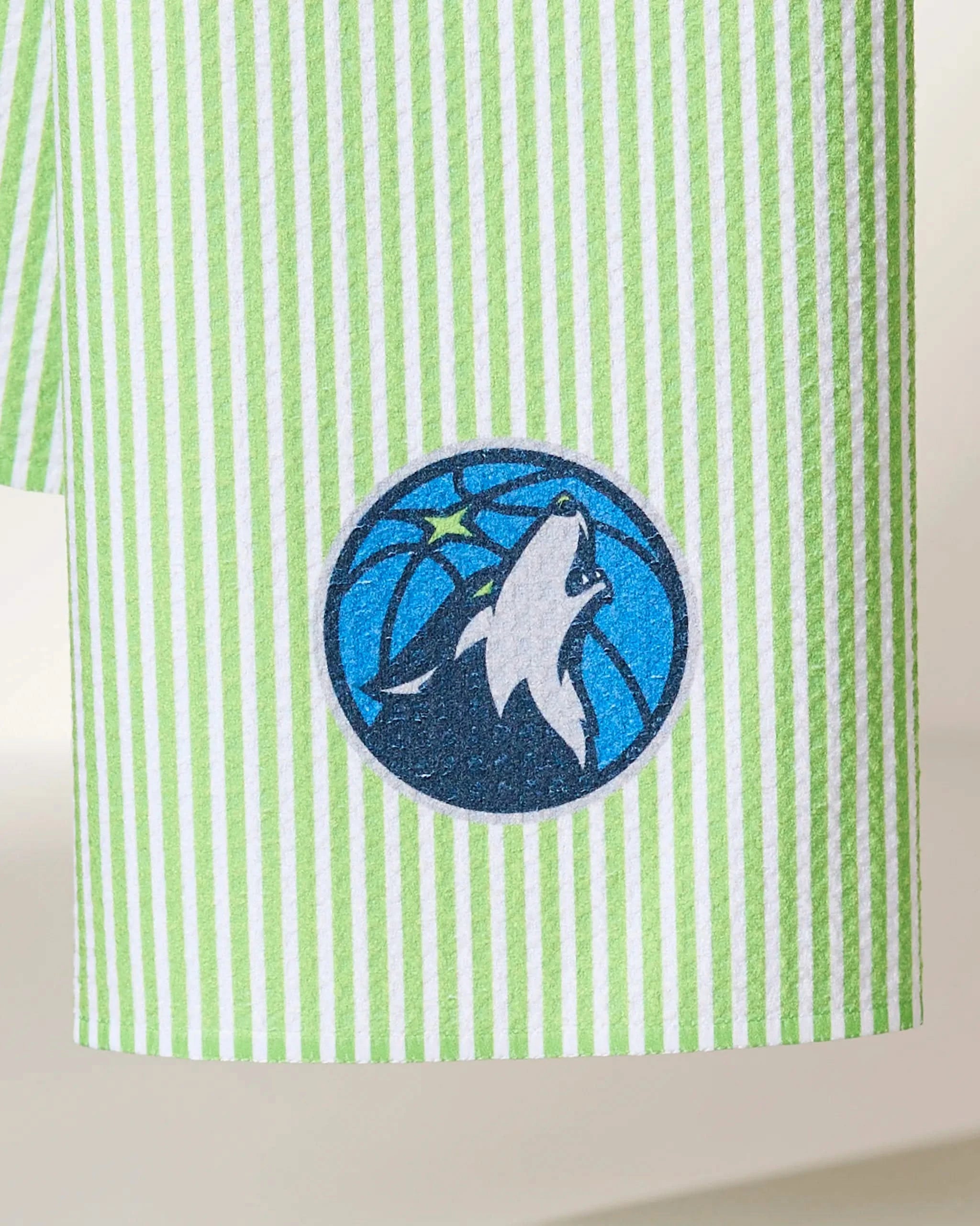 The Geometry Timberwolves Classic features green and white vertical stripes with the Minnesota Timberwolves logo—a howling wolf in front of a blue basketball and green star.