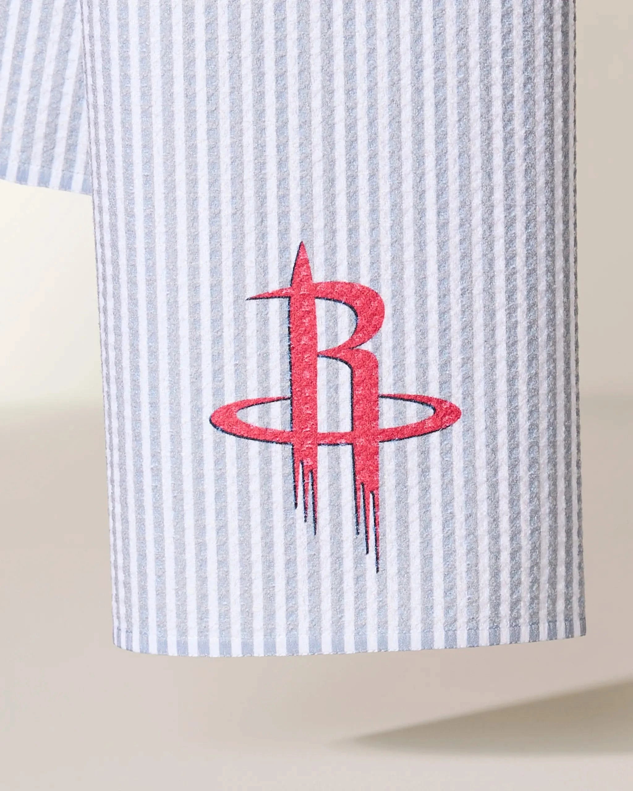 A close-up of the Geometry Rockets Classic, featuring blue and white vertical pinstriped fabric with the red Houston Rockets logo embroidered on it.