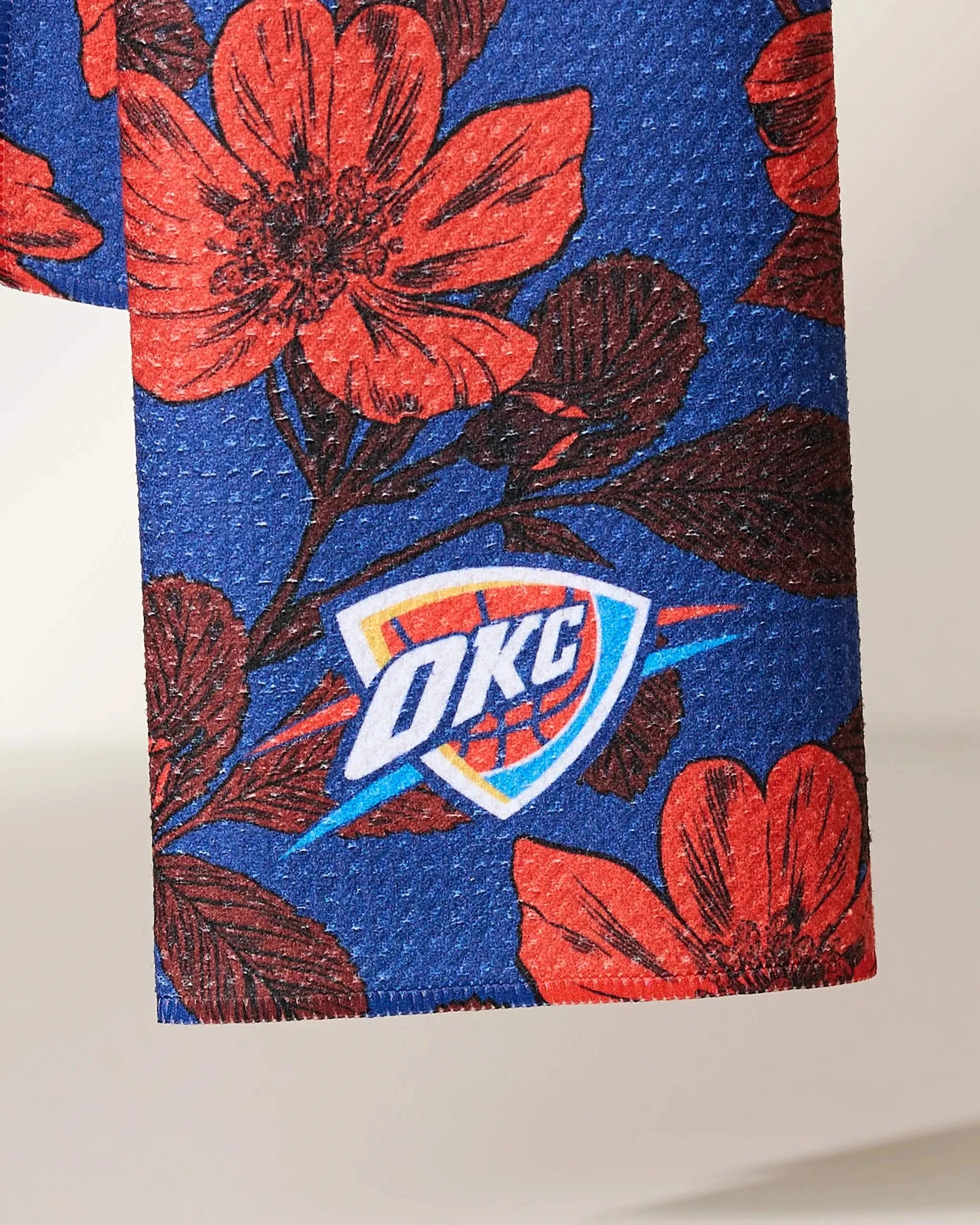 Close-up of Geometrys OKC Floral fabric, featuring a blue base with a red floral pattern and the Oklahoma City Thunder (OKC) logo.