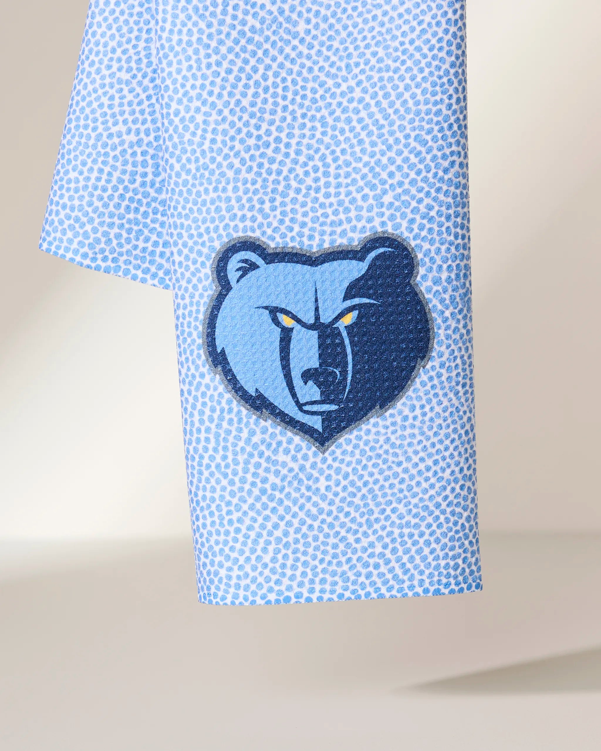 The Geometry Grizzlies Grip tie is light blue with a small repeating dotted pattern and features an embroidered Memphis Grizzlies bear head logo near the bottom.