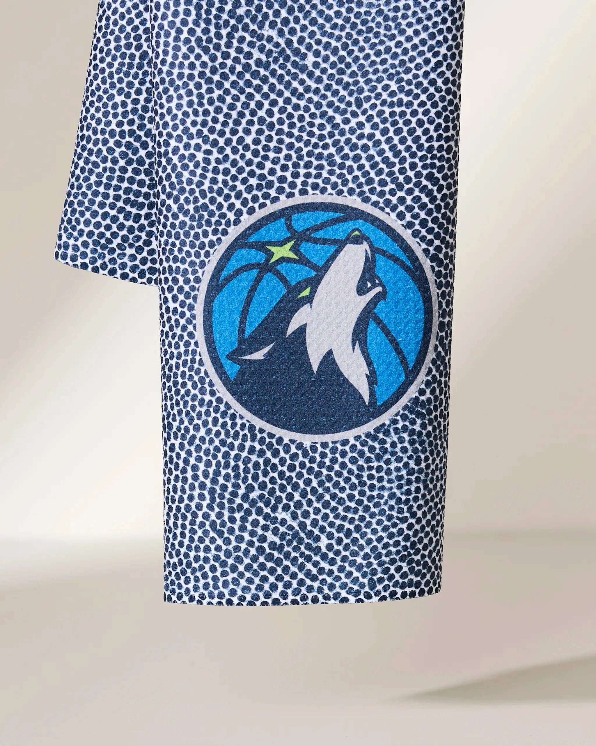 The Timberwolves Grip by Geometry features a blue and white dotted fabric with the Minnesota Timberwolves logo—a howling wolf inside a blue basketball accented by a green star.