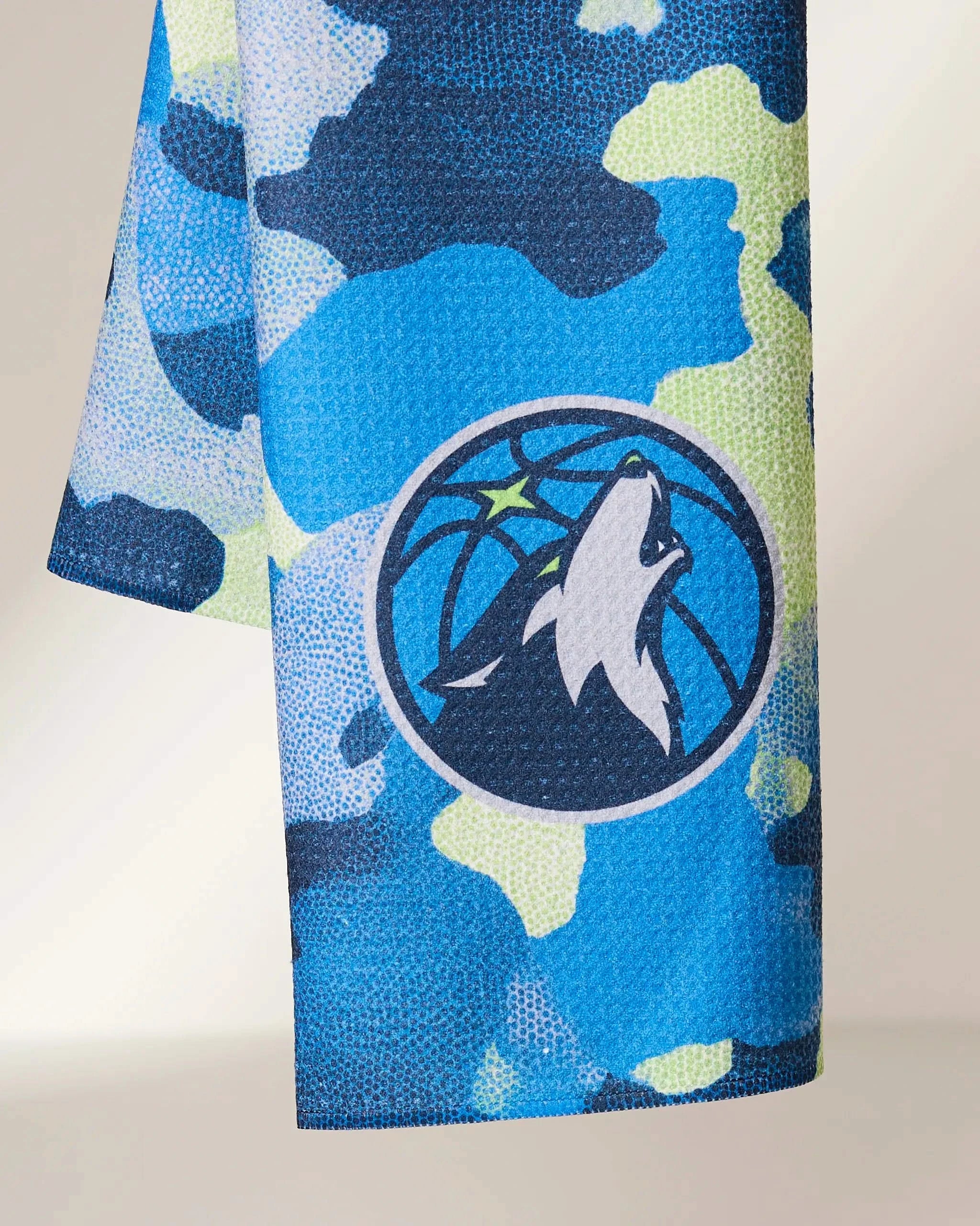Geometrys Timberwolves Camo is a blue, yellow, and navy camouflage-patterned fabric featuring the Minnesota Timberwolves logo with a howling wolf in a basketball circle.