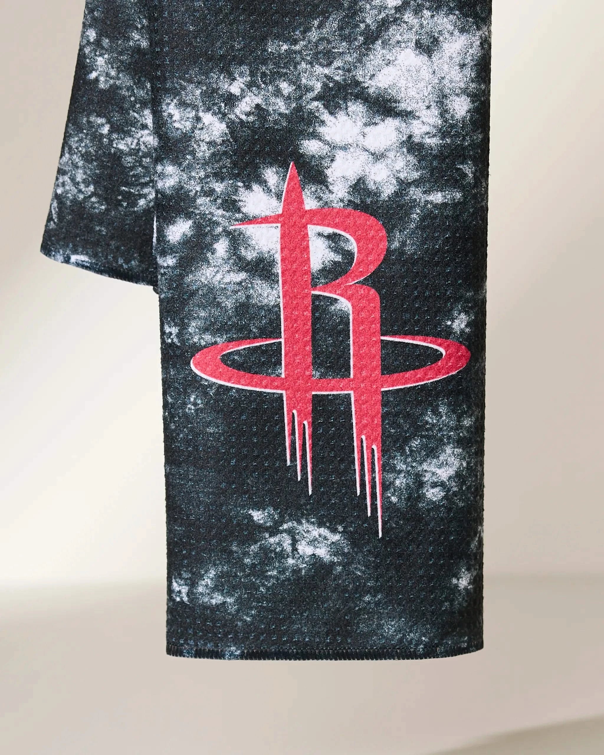 A close-up of the Geometry Rockets Flash, a black and white tie-dye fabric adorned with the red Houston Rockets logo.