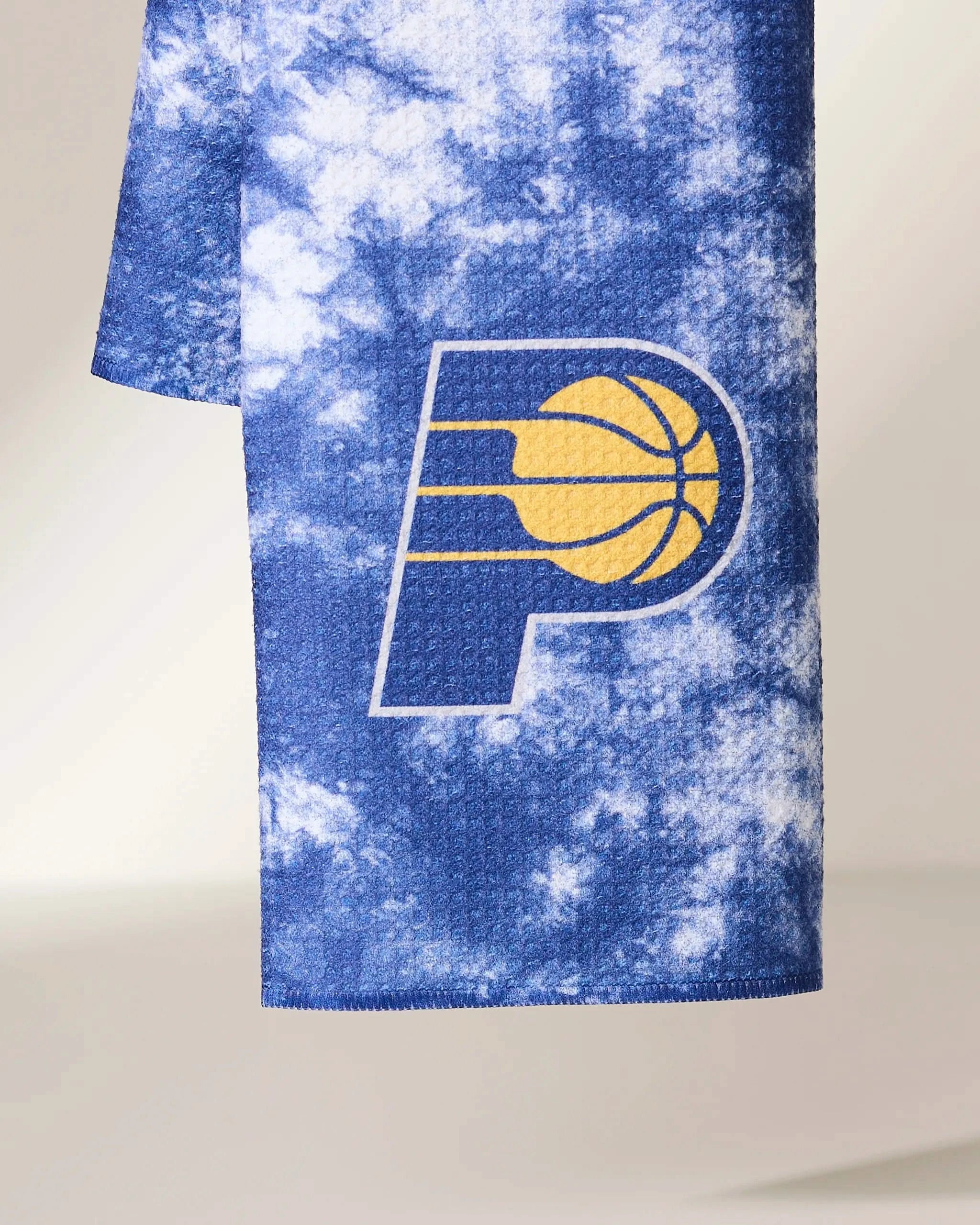 The Geometry Pacers Flash towel is blue and white tie-dye, featuring the Indiana Pacers basketball logo with a large yellow and white P near the bottom center.