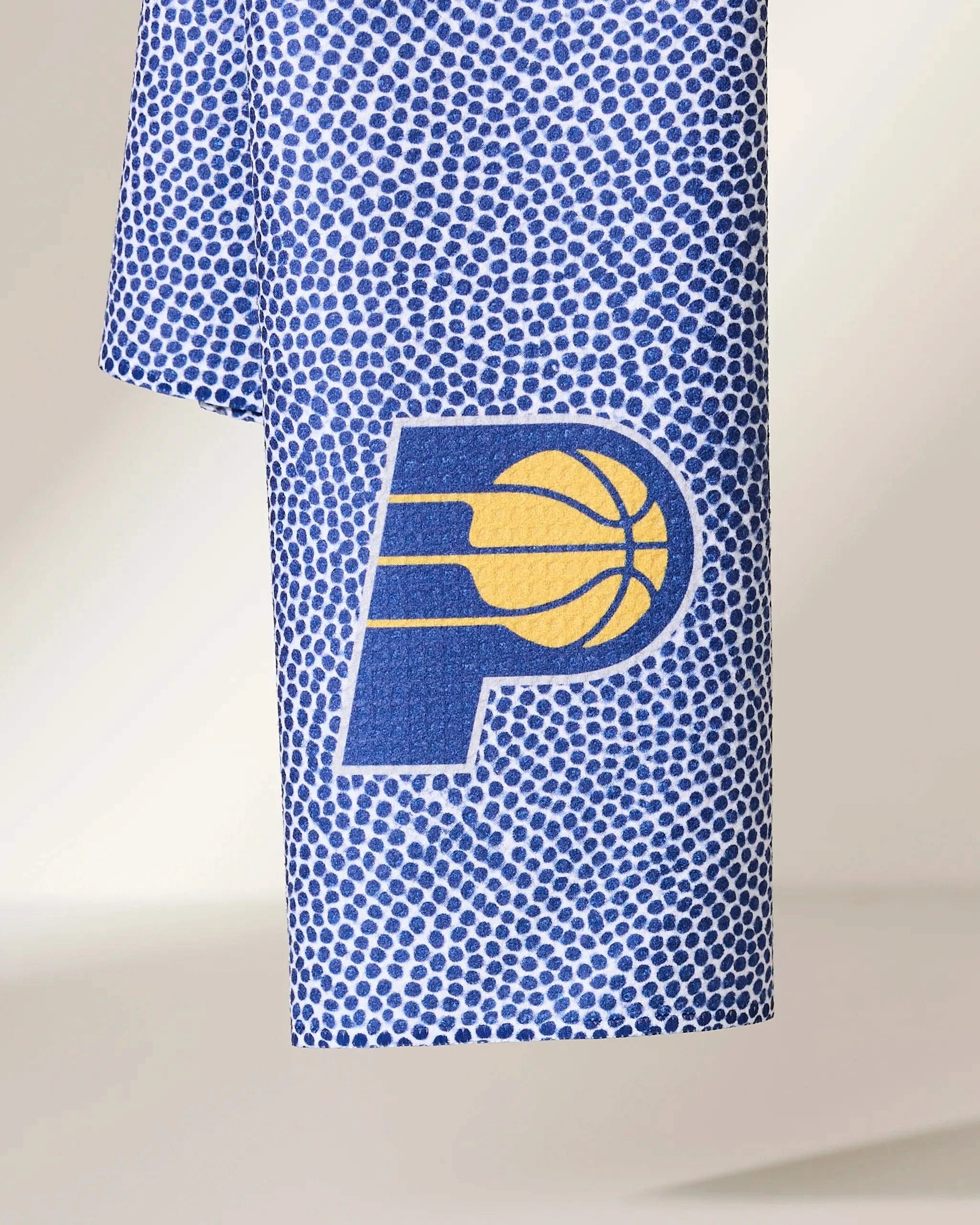 The Pacers Grip by Geometry is a blue and white towel with small dots and the Indiana Pacers logo—a yellow basketball and P—featured at the center.