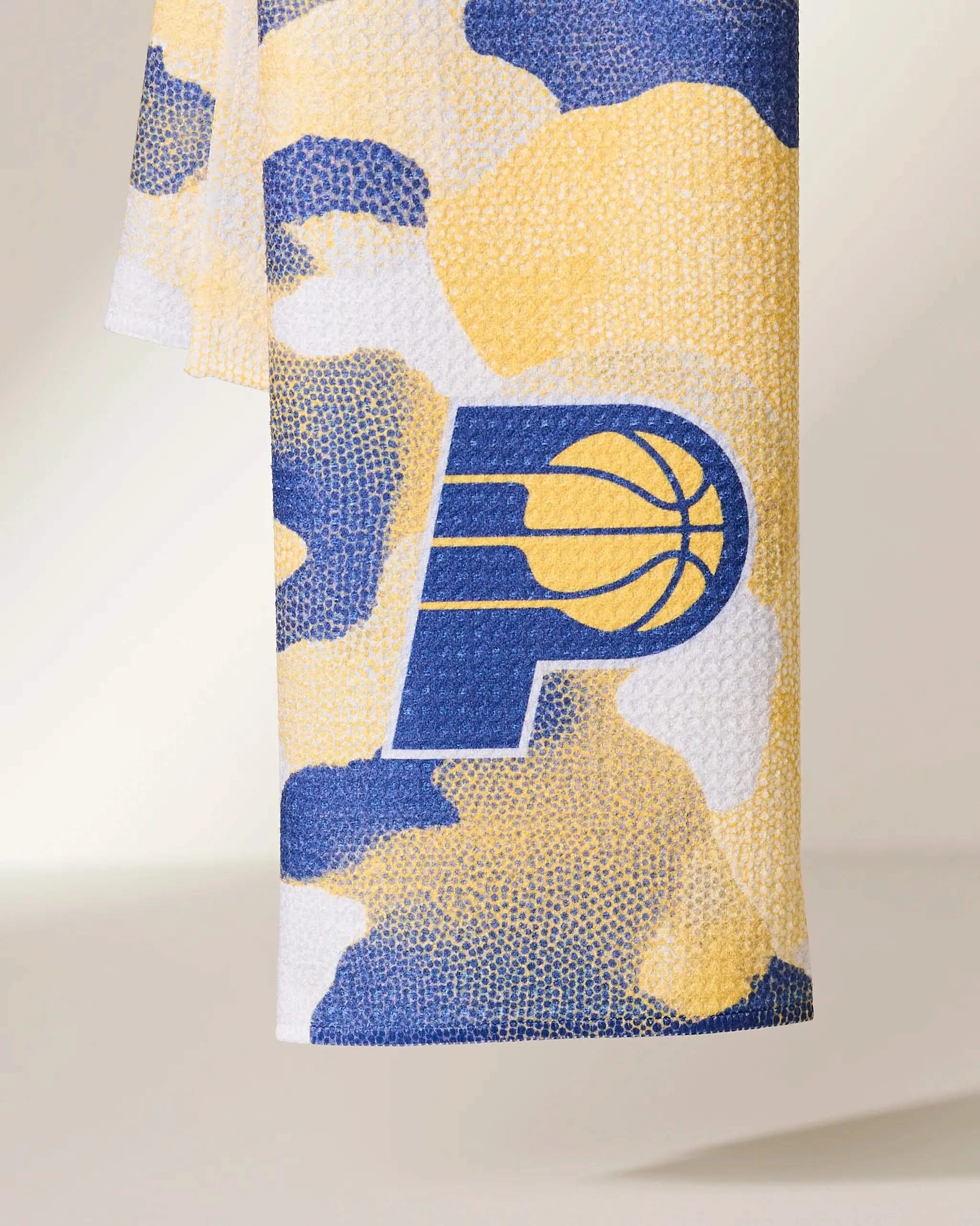 The Geometry Pacers Camo towel features a blue, yellow, and white camo design with the Indiana Pacers team logo in matching colors.