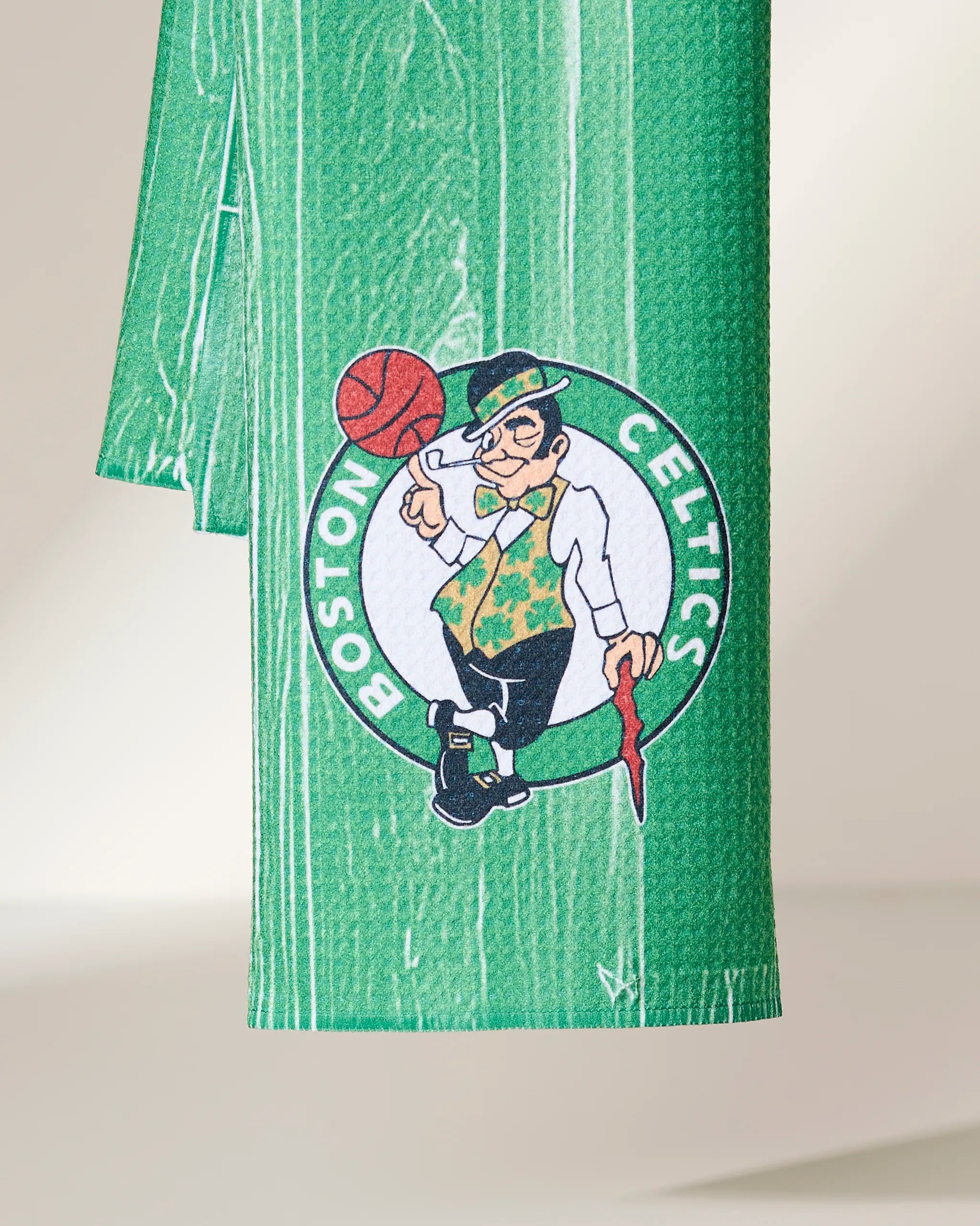 Celtics Zone by Geometry: a green fabric featuring the Boston Celtics logo with a leprechaun spinning a basketball and holding a cane, shown on a neutral backdrop.