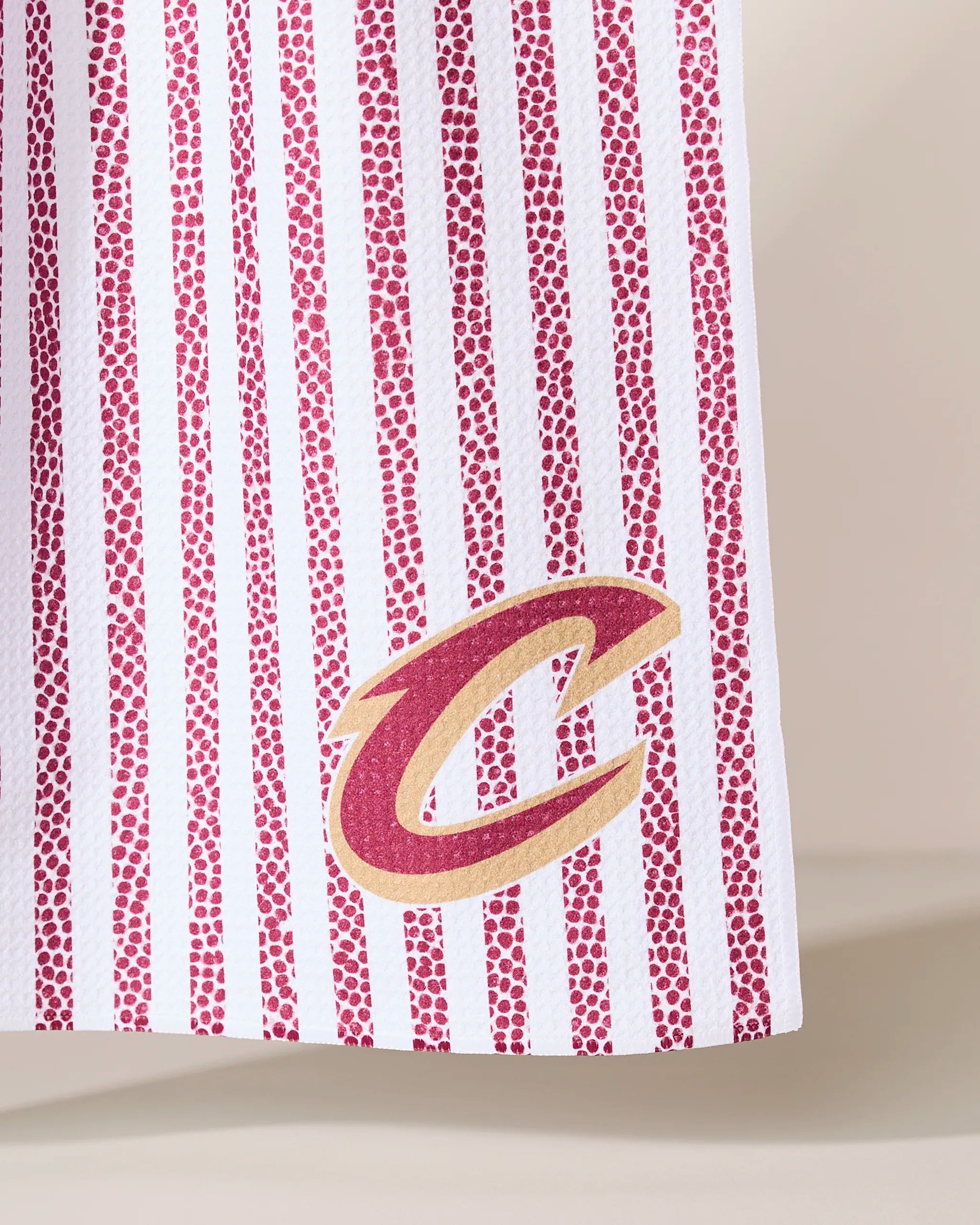 The Geometry Cavaliers Grip Stripe features white fabric with vertical maroon dotted stripes and a gold and maroon Cleveland Cavaliers C logo near the bottom edge.