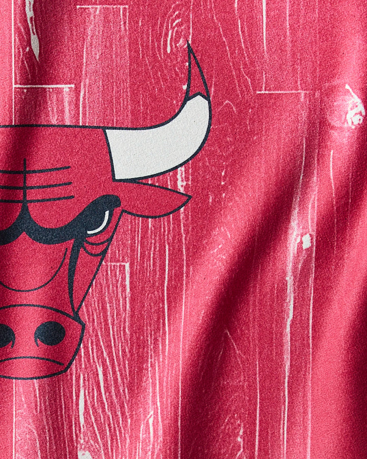 Close-up of the Bulls Zone design by NBALAB x Geometry, showing the left half of a Chicago Bulls logo on a red woodgrain background—ideal for an NBA fitness or quick-dry workout towel.