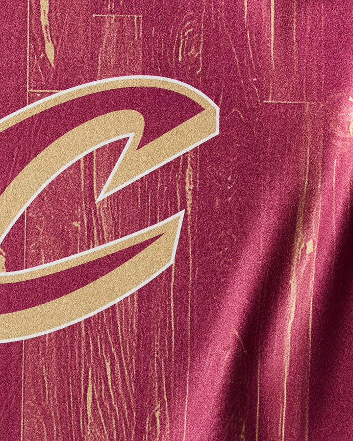 Close-up of the Cavaliers Zone towel by NBALAB x Geometry, featuring maroon Geoweave fabric with a gold and white outlined 'C' logo on a wood grain-inspired texture—ideal for NBA fans and perfect as a fitness towel.