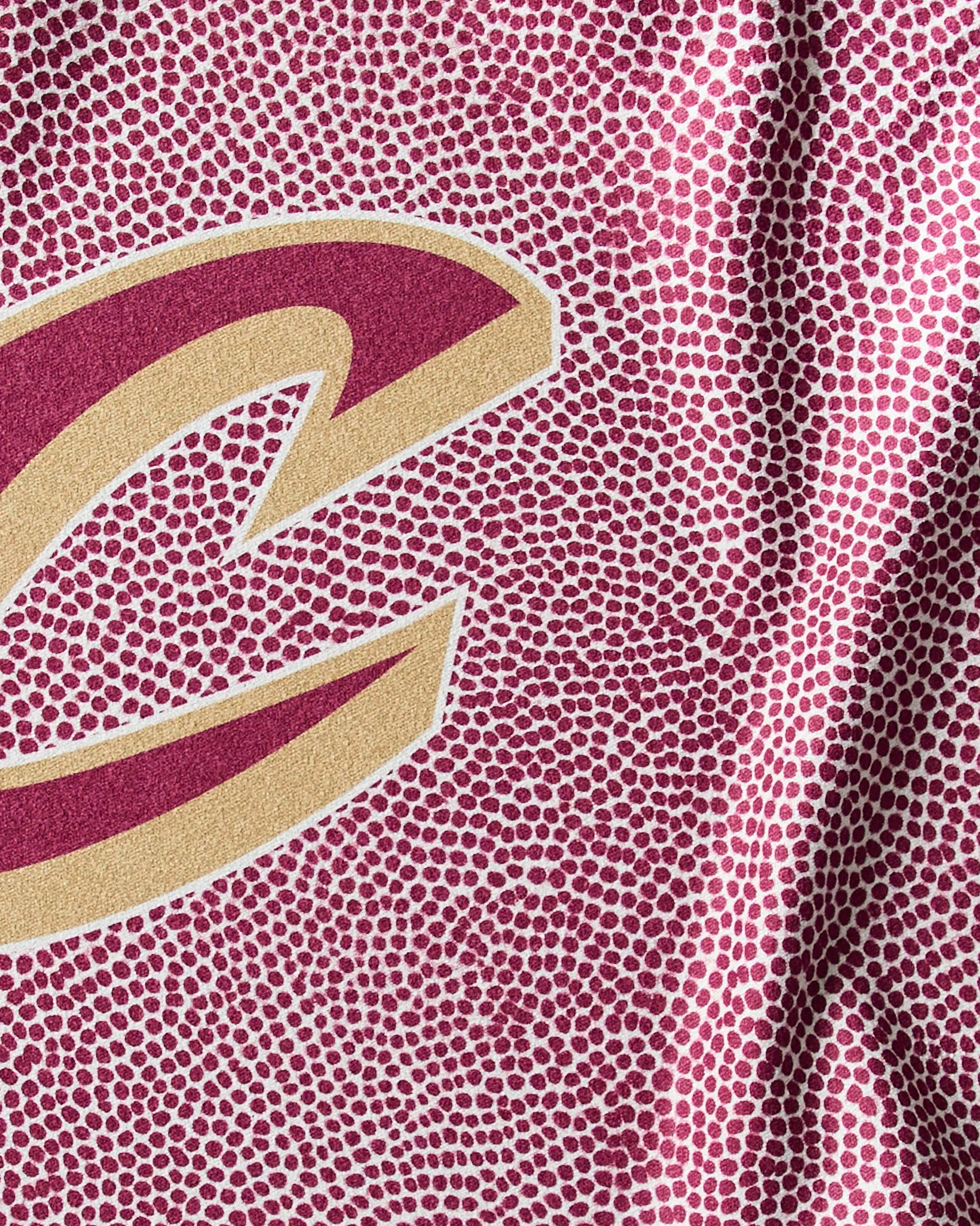 Close-up of the Cavaliers Grip by Geometry, a maroon NBA fitness towel with small raised dots and a partial gold-maroon C, designed for quick-drying performance during intense workouts.