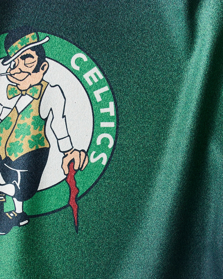 Close-up of the Celtics Fade gym towel by NBALAB x Geometry—a green, quick-drying towel showcasing the Boston Celtics logo with a cartoon leprechaun spinning a basketball.