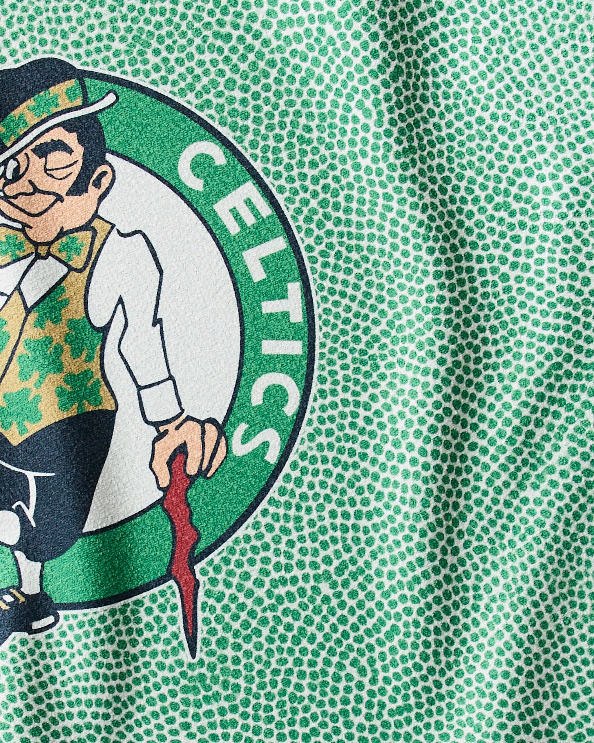Close-up of the Boston Celtics leprechaun logo on a green dotted fabric—ideal inspiration for your Geometry Celtics Grip NBA fitness towel or sustainable workout towel.
