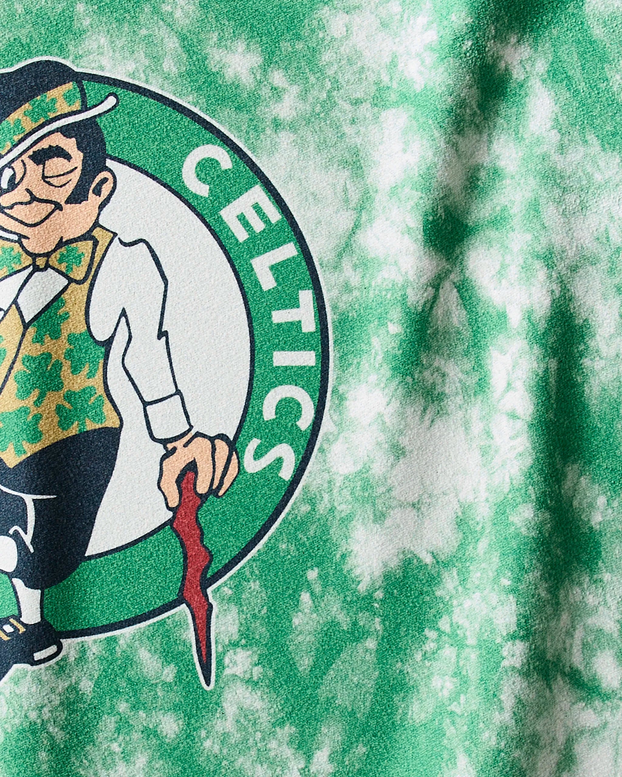 Close-up of the Celtics Flash NBA fitness towel by Geometry, showcasing the Boston Celtics logo with a leprechaun in a green hat, vest, and bow tie against a white and green marbled background—perfect for devoted fans.