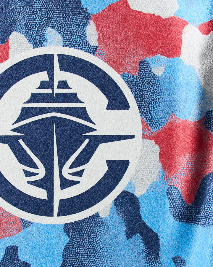 A close-up of the Clippers Camo quick-drying gym towel by NBALAB x Geometry, showing its blue, red, and white camouflage pattern with a bold navy and white circular logo featuring a stylized cruise ship at the center.
