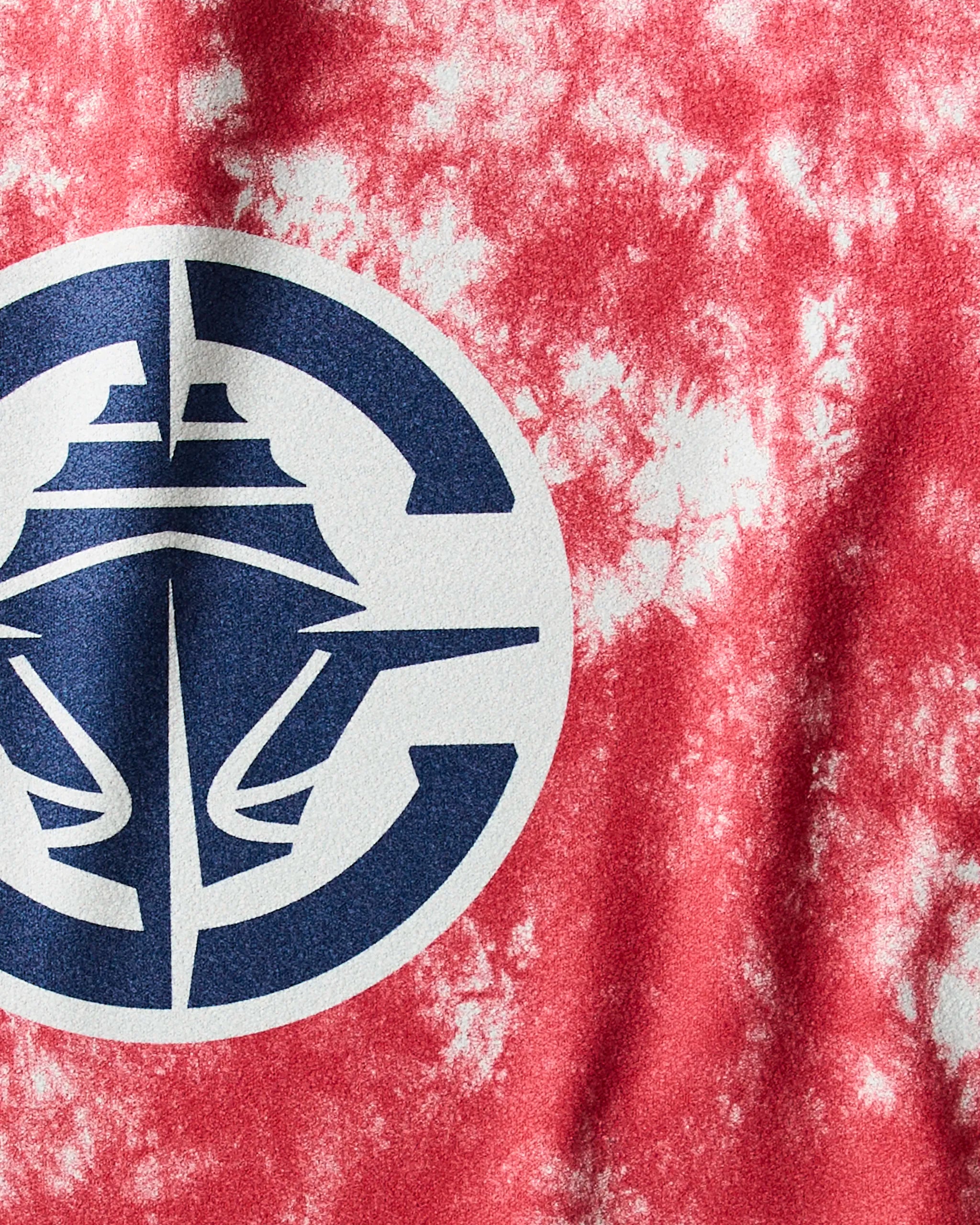 A close-up of the Geometry Clippers Flash, a red and white tie-dye ultra-absorbent workout towel with a blue and white circular logo featuring a stylized ship at the center.