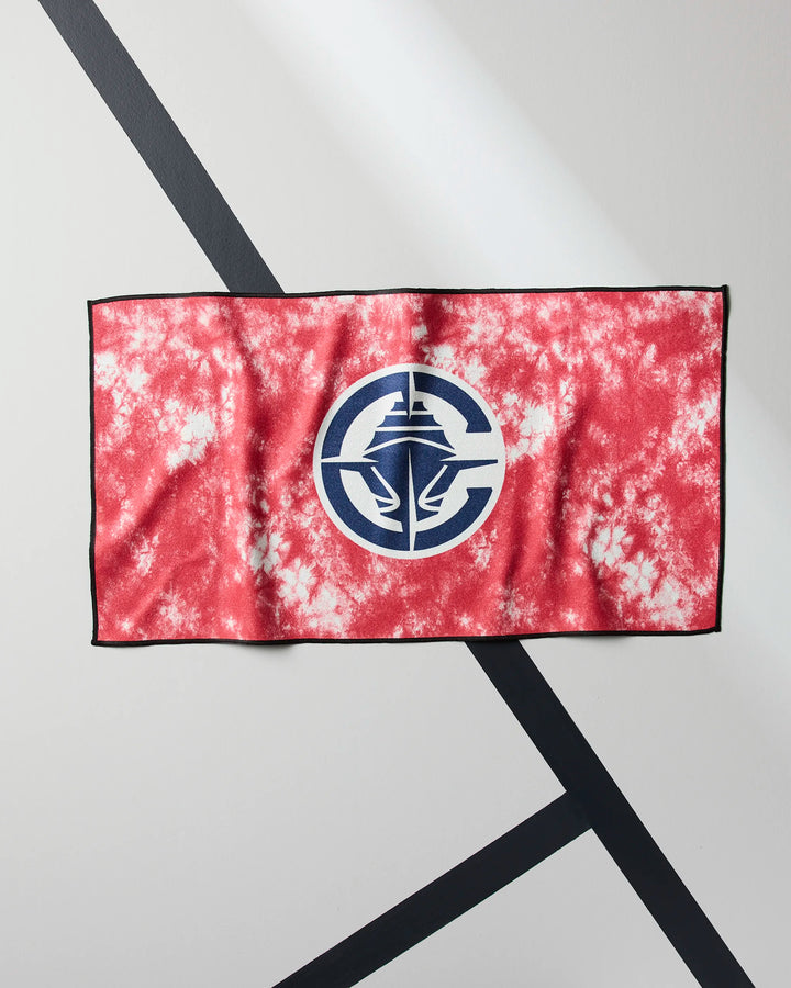 The Clippers Flash by NBALAB x Geometry is a red and white tie-dye NBA fitness towel featuring a blue and white circular logo with hands holding a tower, made from sustainable Geoweave fabric, displayed on a light surface with black intersecting lines.