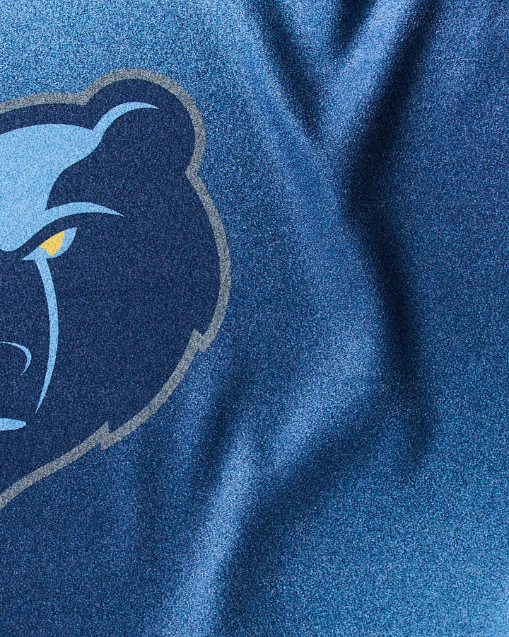Close-up of the Grizzlies Fade fitness towel by NBALAB x Geometry, showcasing a blue design with the Memphis Grizzlies logo—a stylized bear head with a fierce yellow eye.