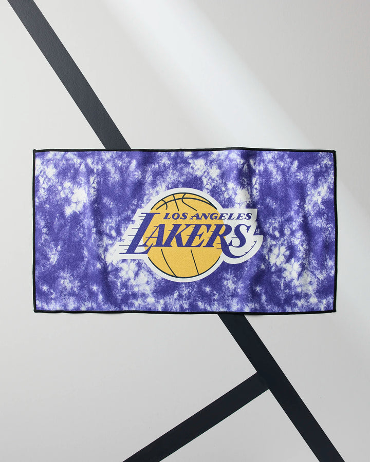 The Lakers Flash by NBALAB x Geometry is a purple tie-dye NBA fitness towel with the Los Angeles Lakers logo, yellow basketball, and team name in white and purple, shown flat on a white surface with black diagonal lines.