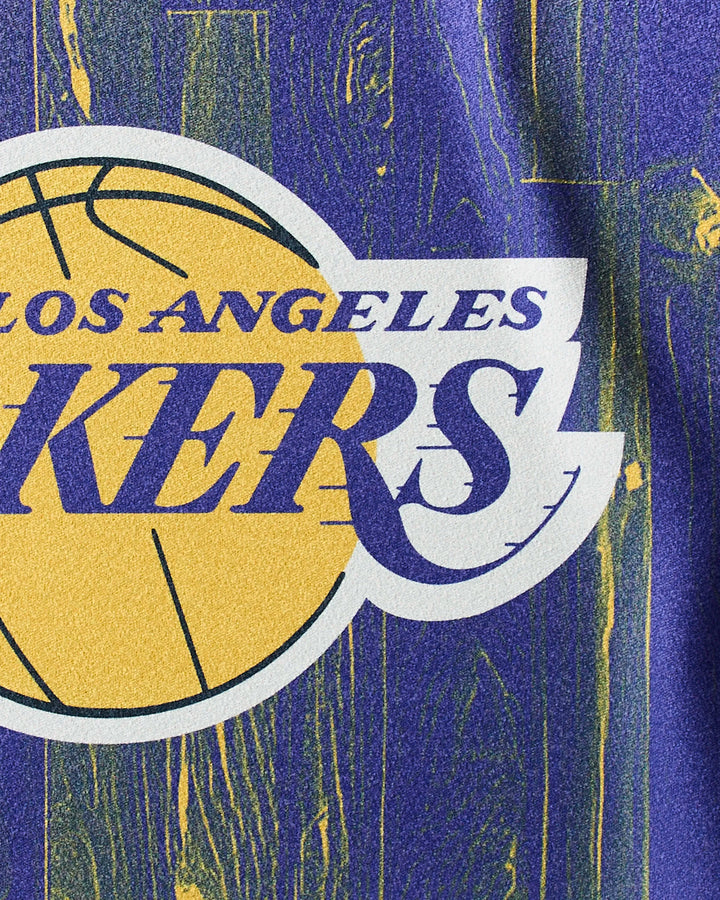 Close-up of the NBALAB x Geometry Lakers Zone gym towel featuring part of a yellow basketball and purple and white text on a blue and yellow background. Quick-drying material with Los Angeles Lakers-inspired design.